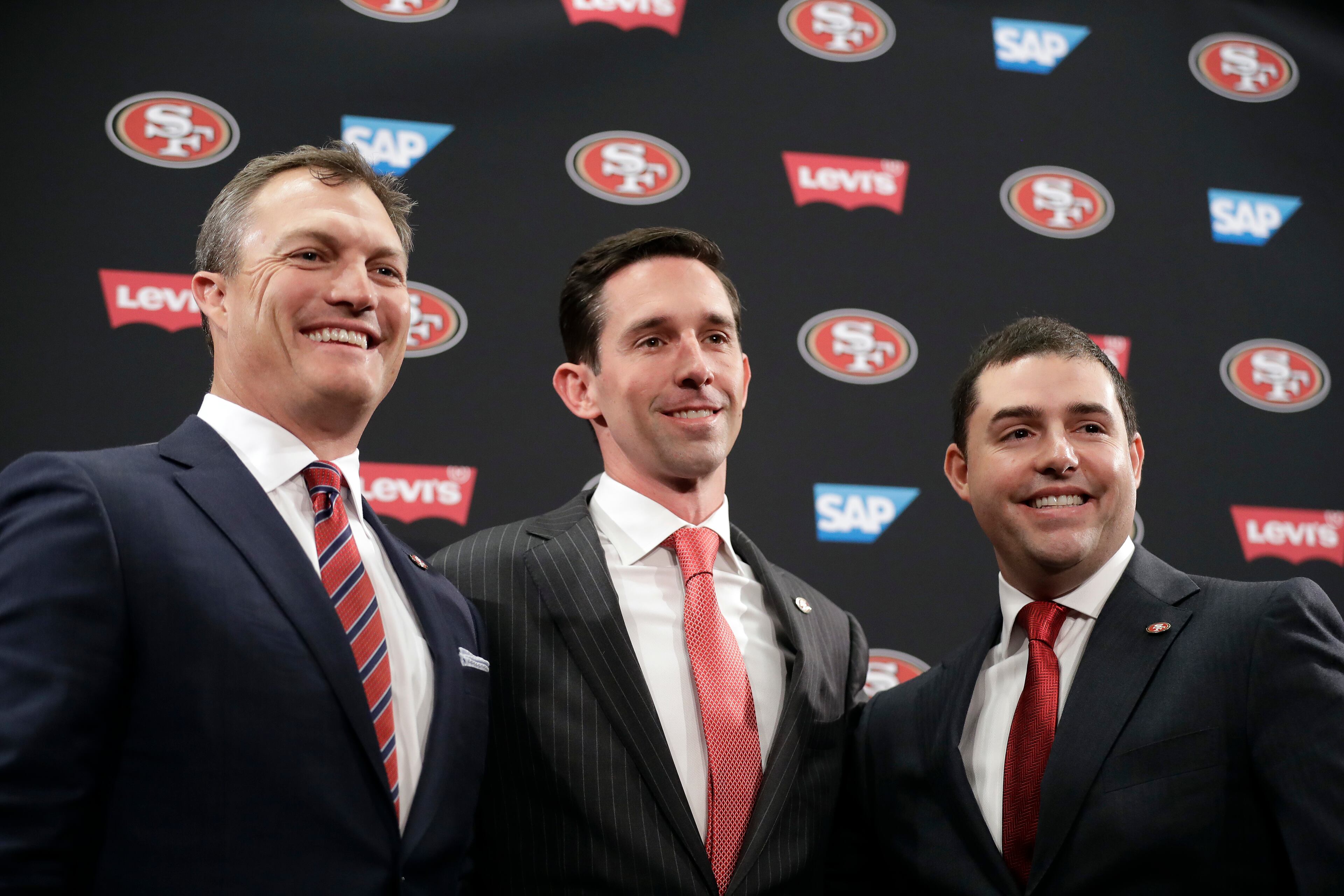 San Francisco 49ers head coach Kyle Shanahan, center, poses for photos next to general manager John Lynch, left, and owner Jed York during an NFL football press conference Thursday, Feb. 9, 2017, in Santa Clara, Calif. (AP Photo/Marcio Jose Sanchez)