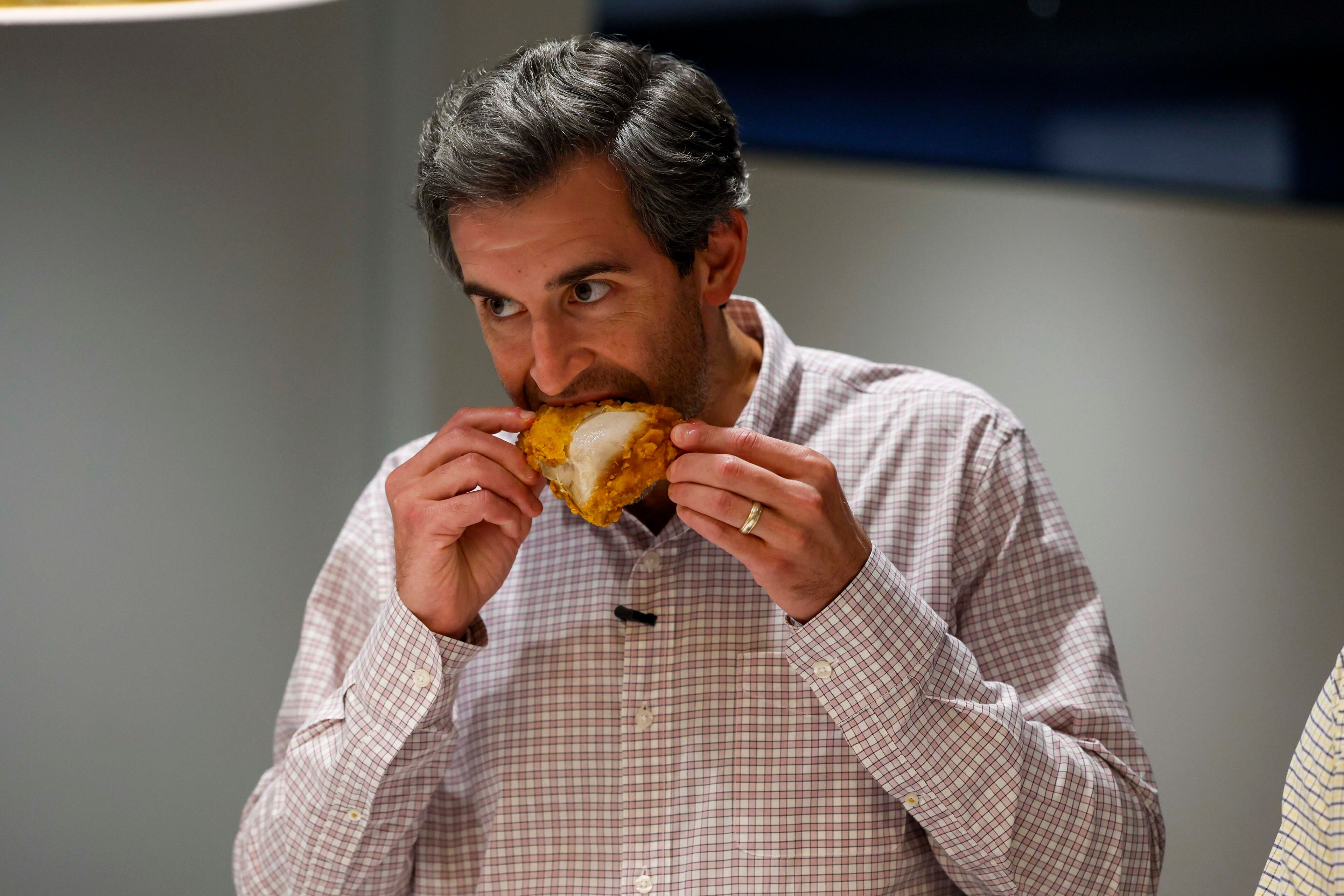 Climate + Environment Reporter Drew Kann takes a bite of fried chicken during a fried chicken contest on Tuesday, Aug. 25, 2026, at the AJC office in Midtown to determine Atlanta’s best fried chicken. (Miguel Martinez/AJC)