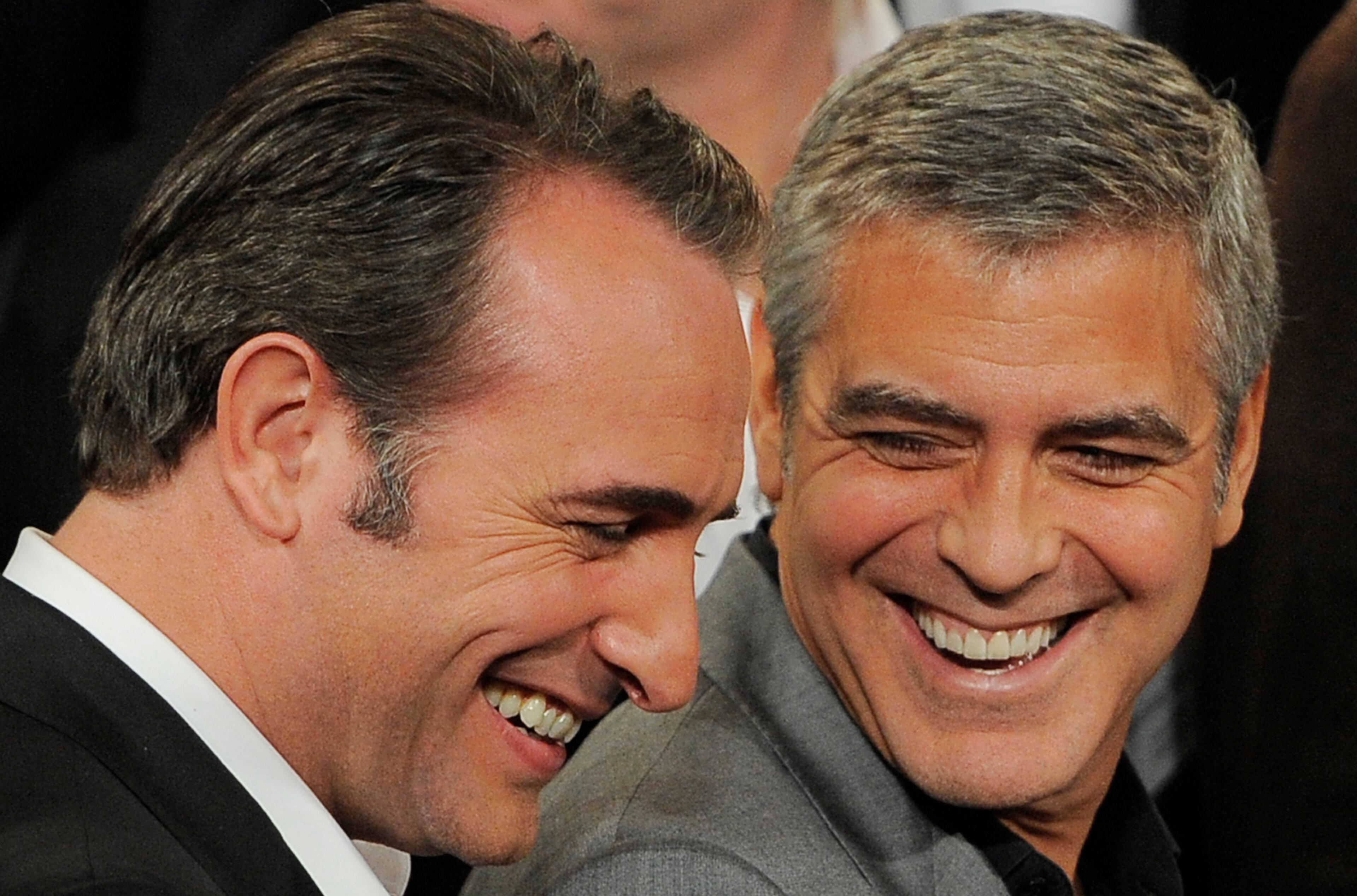 Jean Dujardin, left, a Best Actor nominee for "The Artist," and George Clooney, a Best Actor nominee for "The Descendants," share a laugh during a group photo of the nominees at the 31st Academy Awards Nominees Luncheon in Beverly Hills, Calif., Monday, Feb. 6, 2012. The 84th Academy Awards will be held in Los Angeles on Sunday, Feb. 26. (AP Photo/Chris Pizzello)