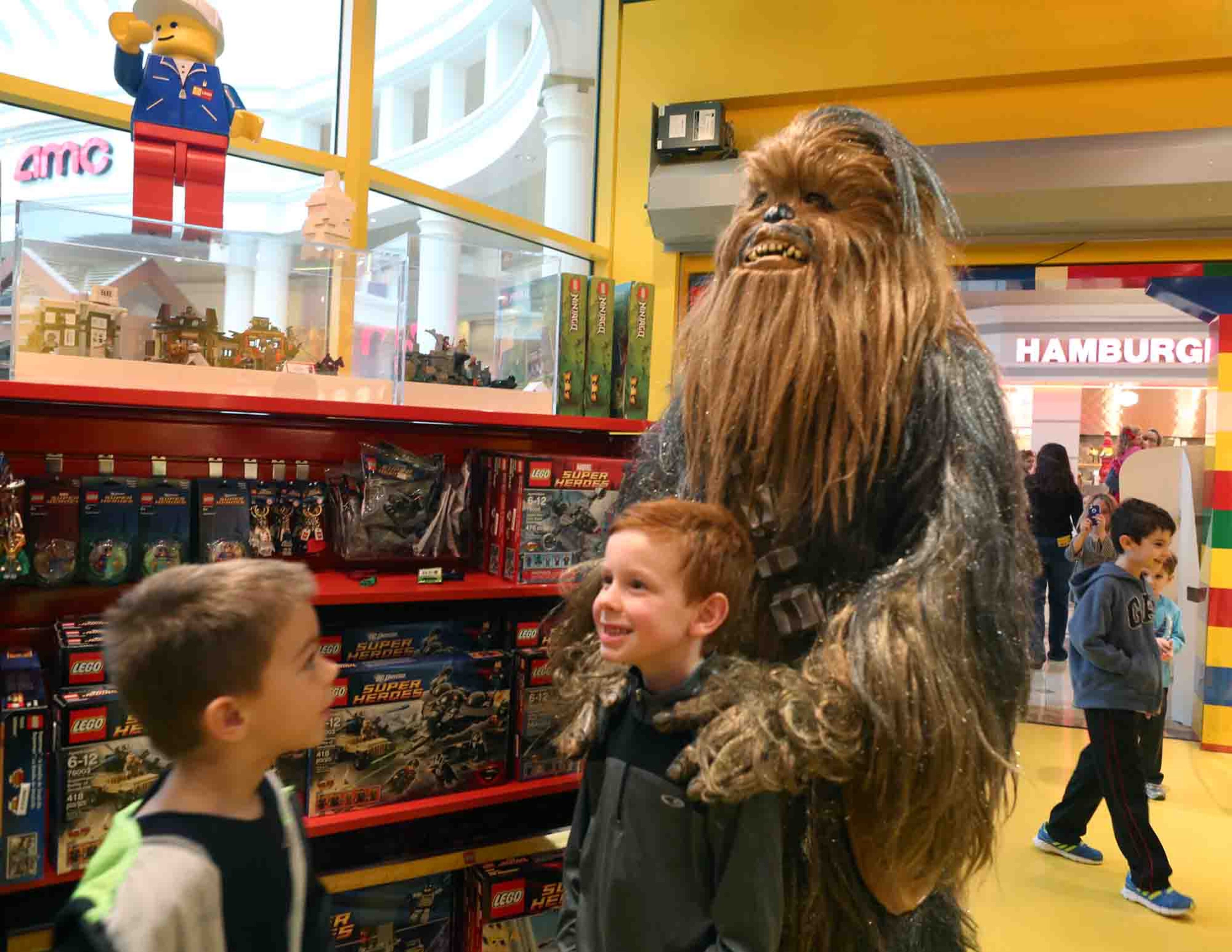 Six-year-old Riley Newbold poses with Star Wars character Chewbacca as his friend Ryan Dittmore, 6, looks on at Star Wars Day at LEGOLAND Discovery Center in Phipps Plaza on Saturday, Jan. 11, 2014.
