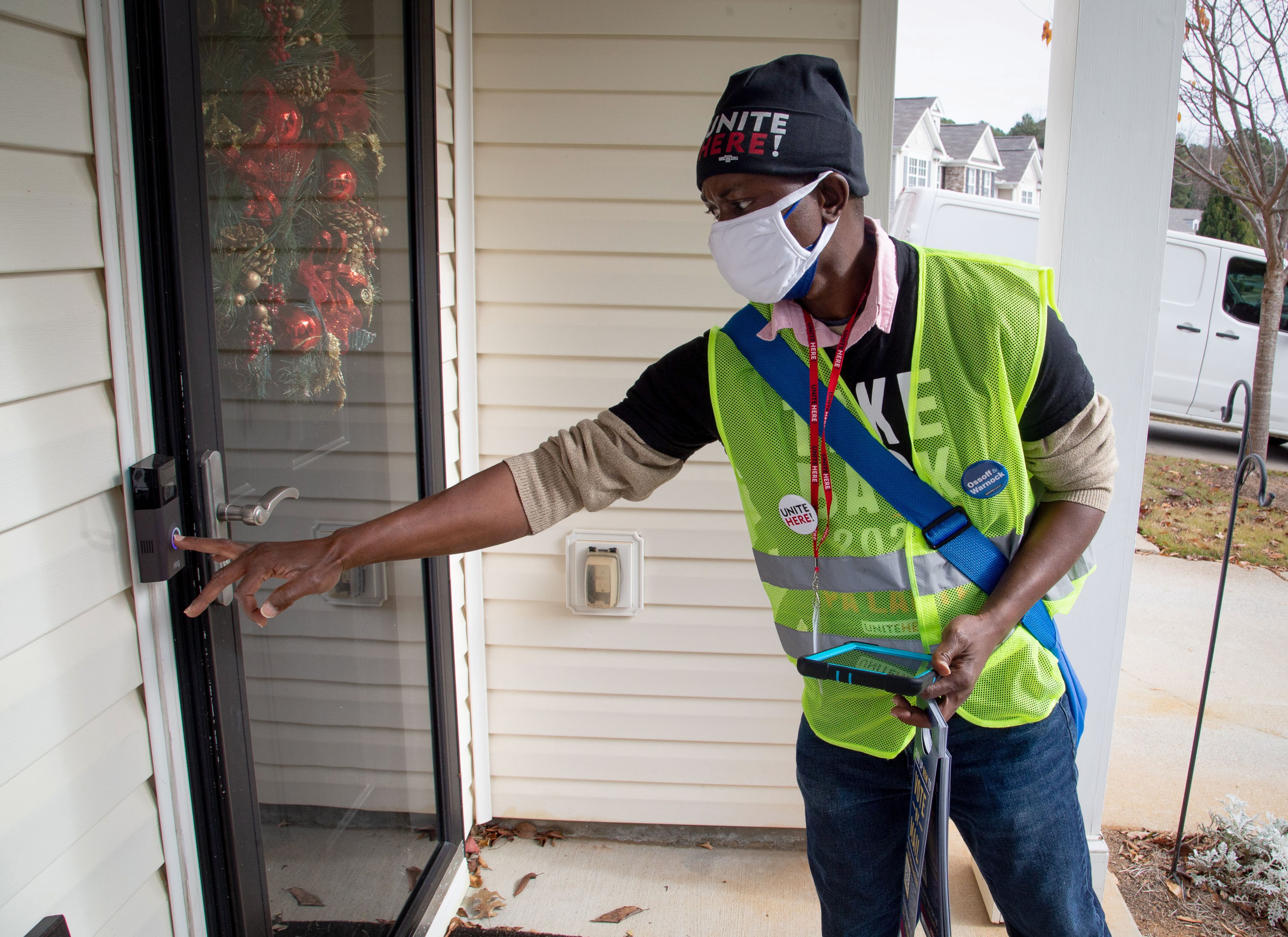 Canvasser Jenkins Kolongbo, who supports the Democrats, rings the doorbell at a house in a Scottdale neighborhood on Dec. 12, 2020. (Steve Schaefer for The Atlanta Journal-Constitution)