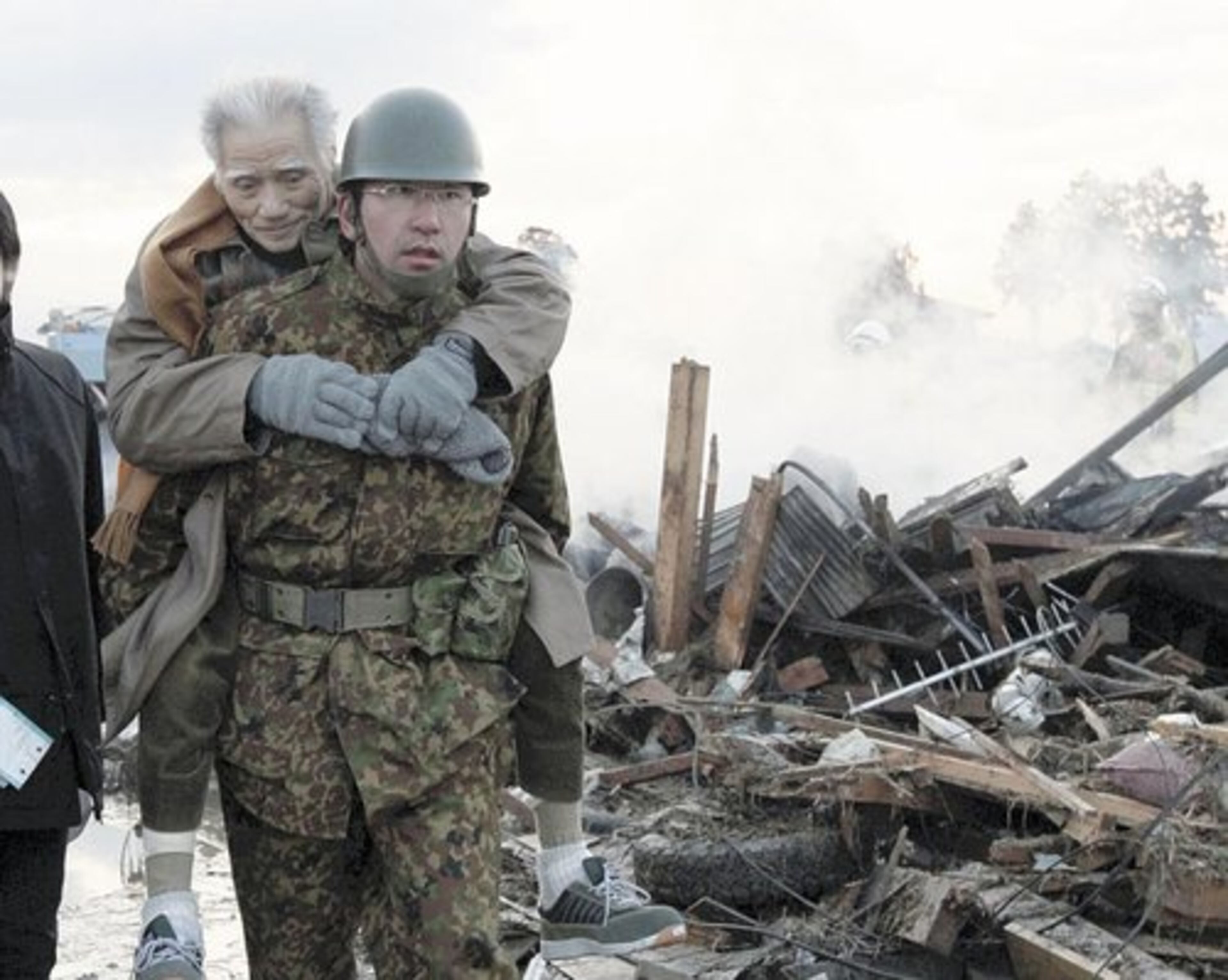 An elderly man is carried by a Self-Defense Force member in tsunami-torn Natori city, Miyagi Prefecture, northern Japan.
