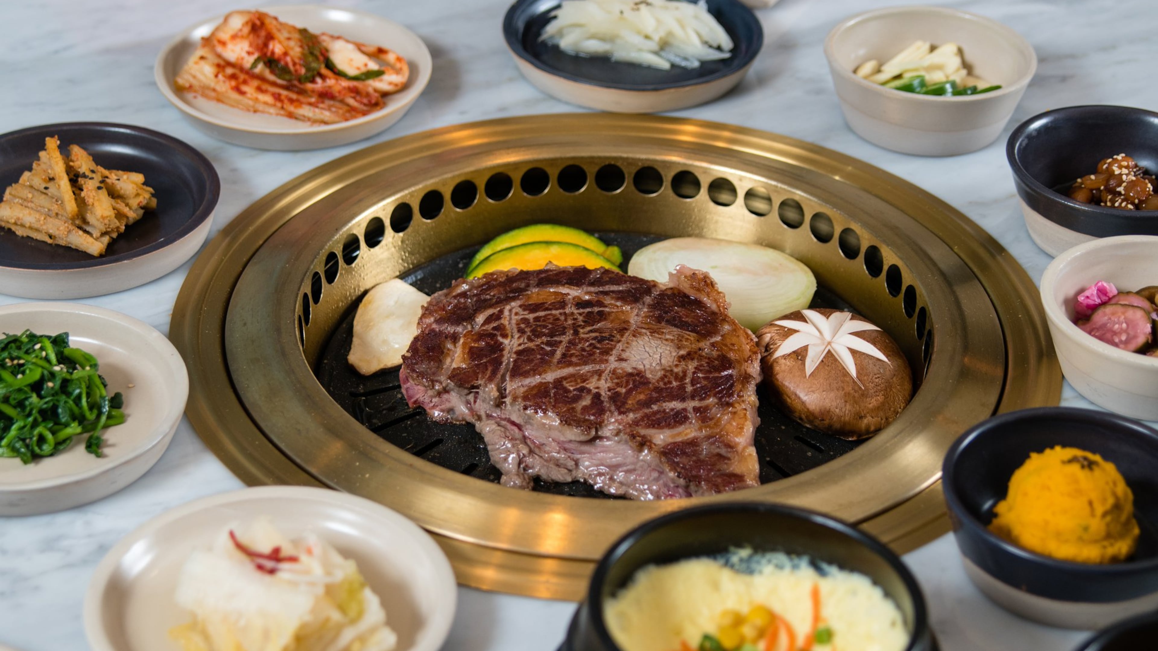 A large prime rib-eye steak cooks on the table-mounted grill at Ari Korean Steakhouse. CONTRIBUTED BY HENRI HOLLIS