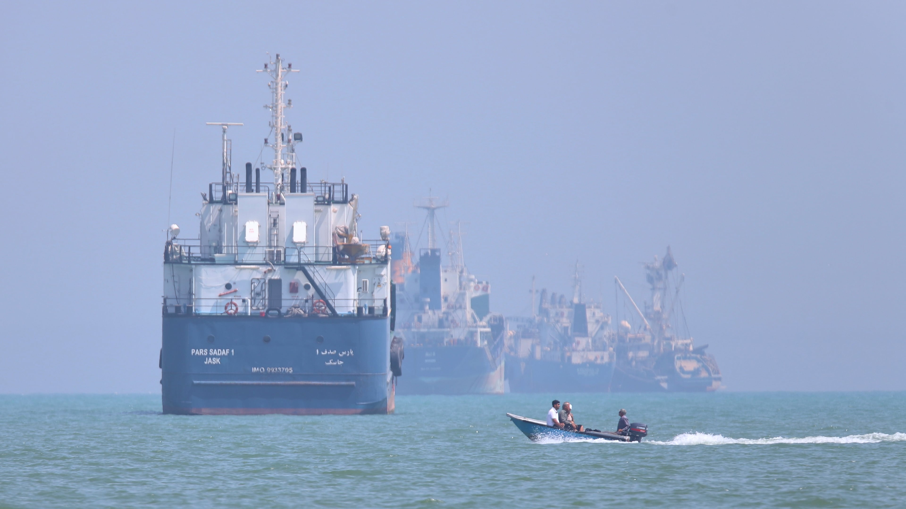 A small motorboat passes anchored vessels in the Strait of Hormuz off Bandar Abbas, Iran, Thursday, June 11, 2026.(Amirhosein Khorgooi/ISNA via AP)