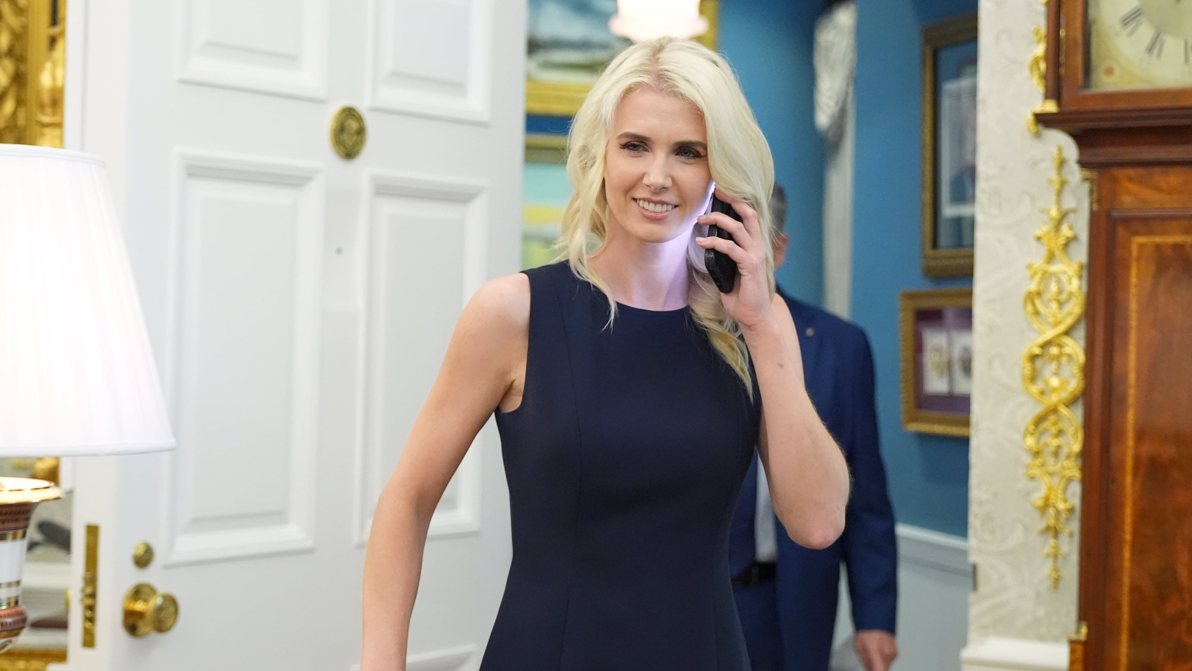 White House aide Natalie Harp is pictured using a cell phone as President Donald Trump speaks during an event about drug prices, in the Oval Office of the White House, Monday, Aug. 31, 2026, in Washington. (AP Photo/Jacquelyn Martin)