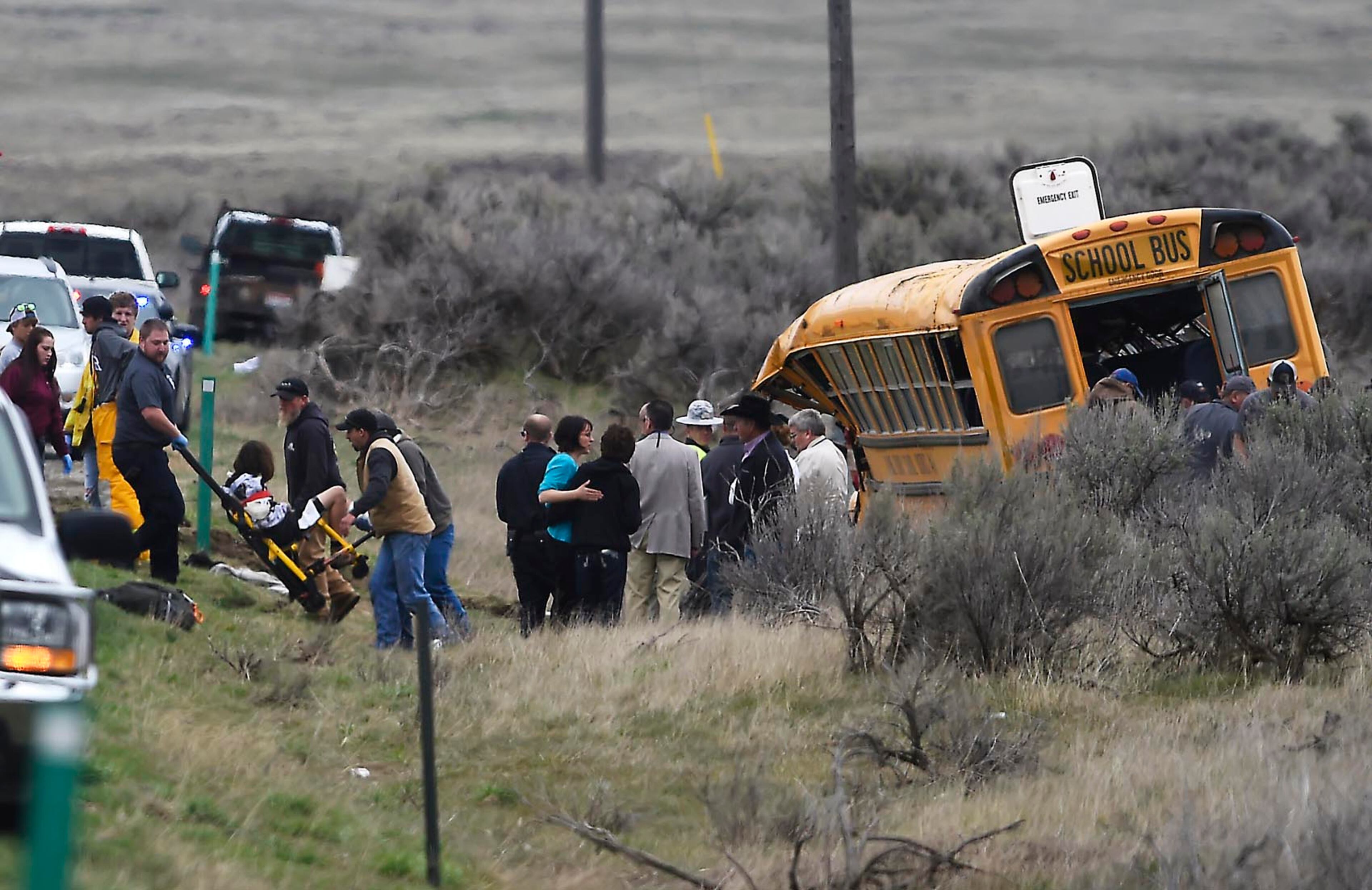Emergency personnel help to remove passengers after school bus that Tuesday, April 18, 2017, west of Richfield, Idaho. At least 17 students have been taken to hospitals, some with serious injuries, after a bus carrying 39 students to a track meet rolled over on a rural stretch of road in central Idaho. (Drew Nash/The Times-News via AP)