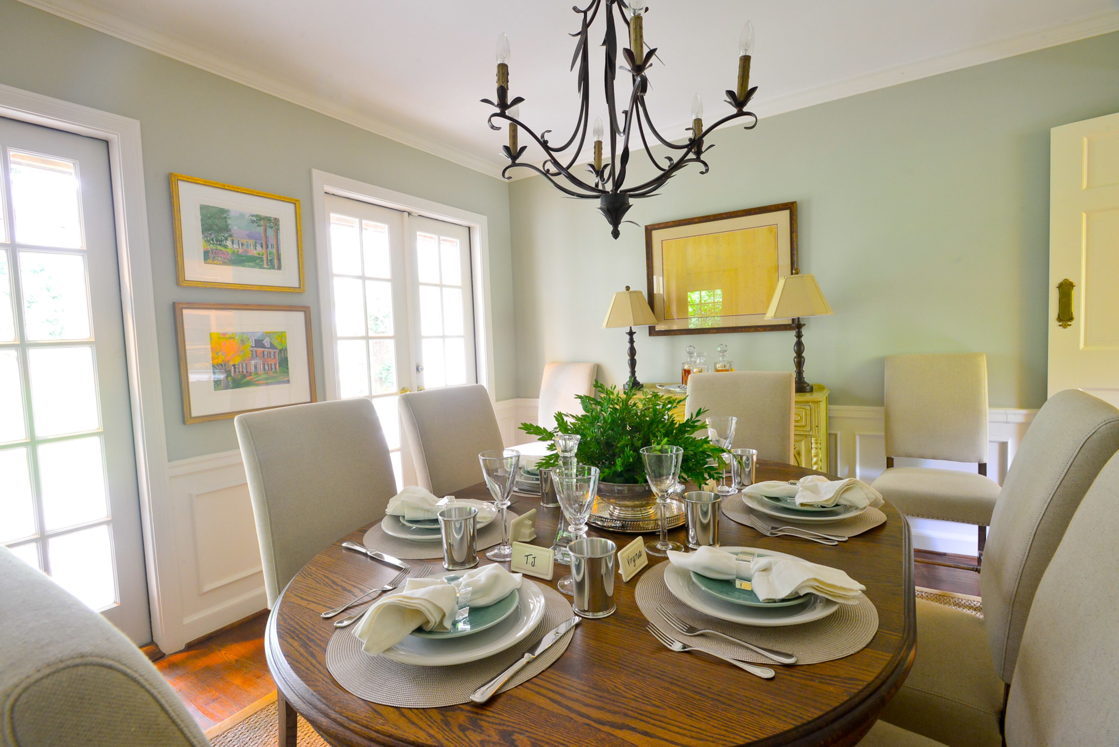 The dining room table is an inherited piece that belonged to Catherine Callaway's grandmother, surrounded by chairs from Havertys. The table is set with dinnerware and glassware from Erika Reade in Atlanta.