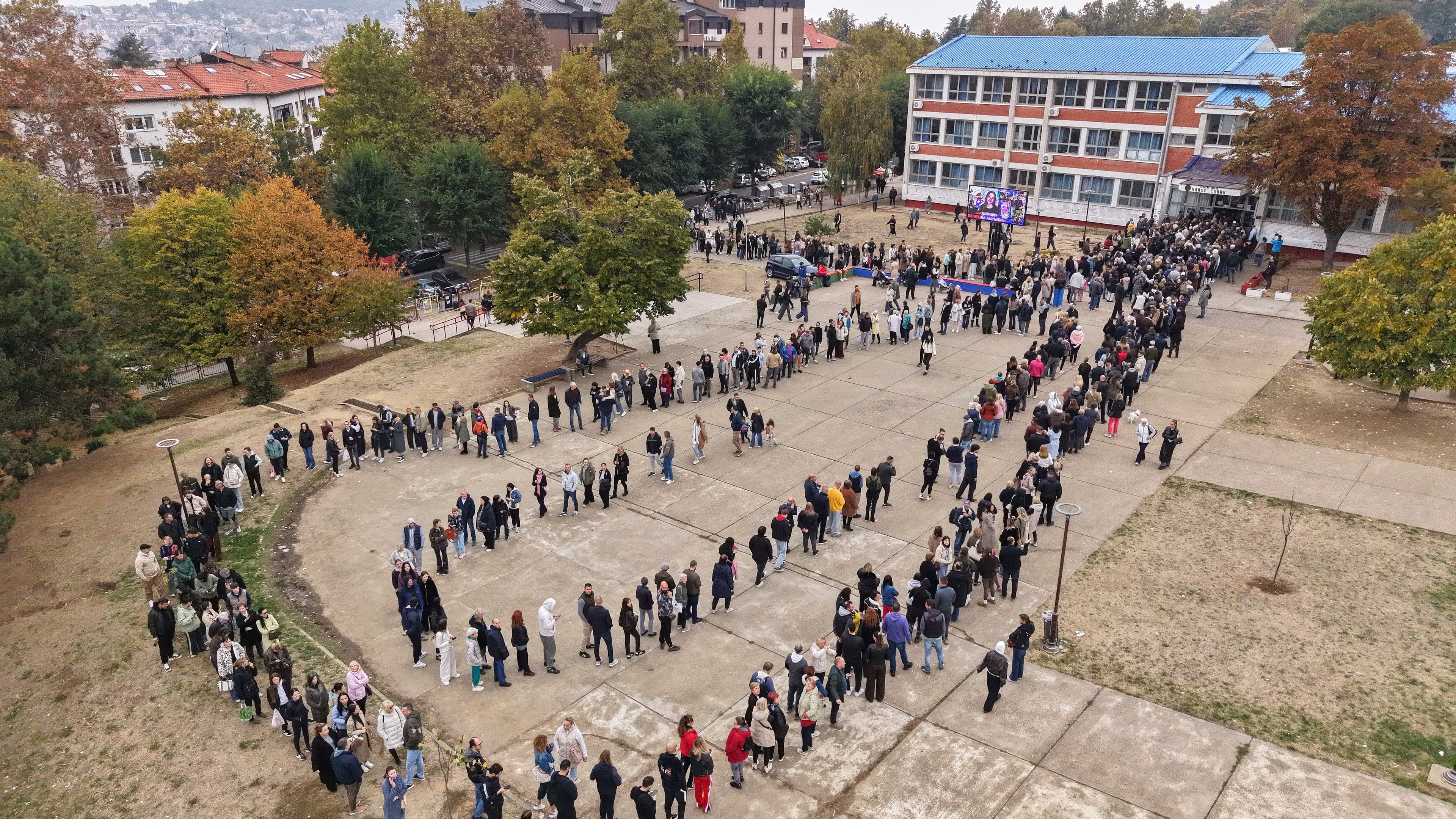 People wait in lines outside a polling station to cast their votes during a parliamentary election in Belgrade, Serbia, Sunday, Oct. 25, 2026. (AP Photo/Armin Durgut)