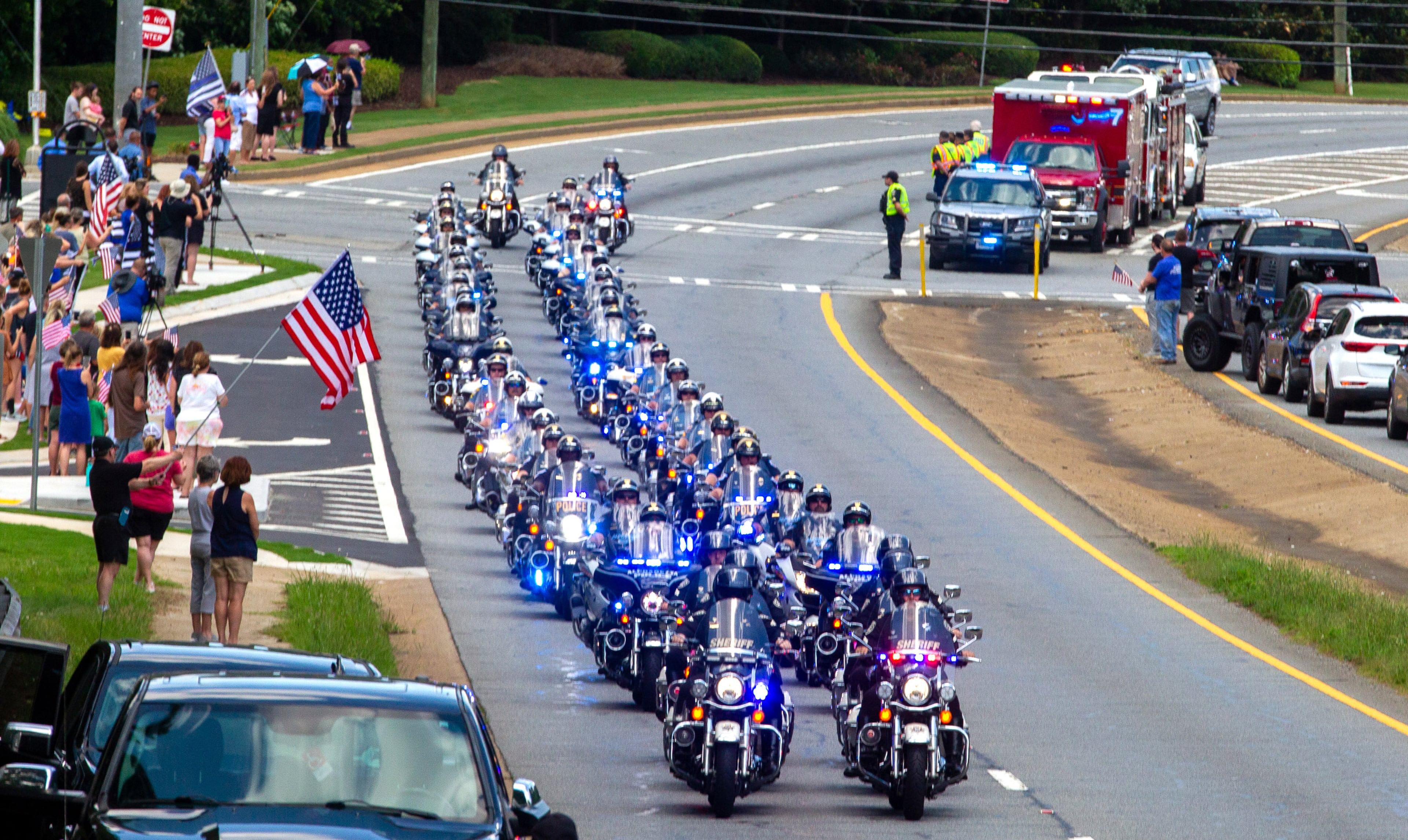 A police escort drives down Highway 92 in Woodstock after the funeral of Holly Springs Police Officer Joe Burson at First Baptist Church of Woodstock on June 21, 2021STEVE SCHAEFER FOR THE ATLANTA JOURNAL-CONSTITUTION