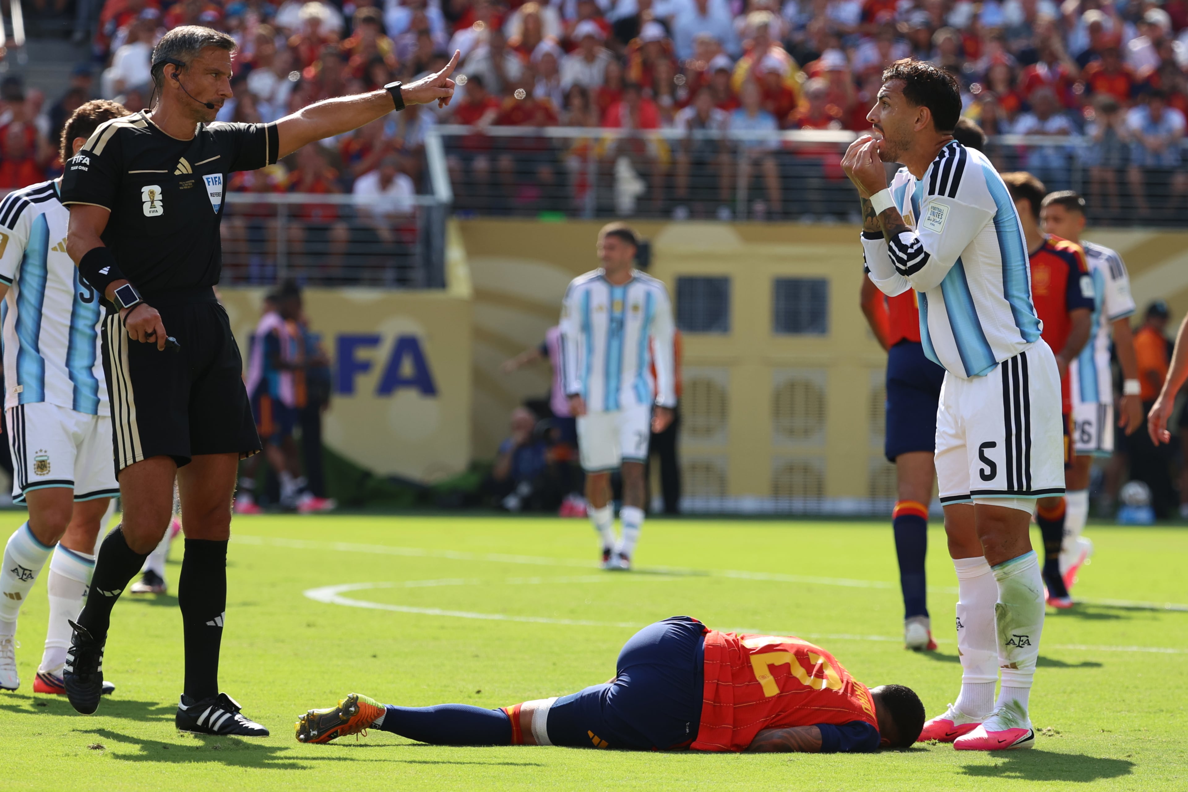 Referee Slavko Vincic (left) gestures as Argentina's Leandro Paredes (right) reacts and Spain's Pedro Porro lies on the ground during the World Cup final soccer match between Spain and Argentina in East Rutherford, N.J., near New York, Sunday, July 19, 2026. (Pamela Smith/AP)