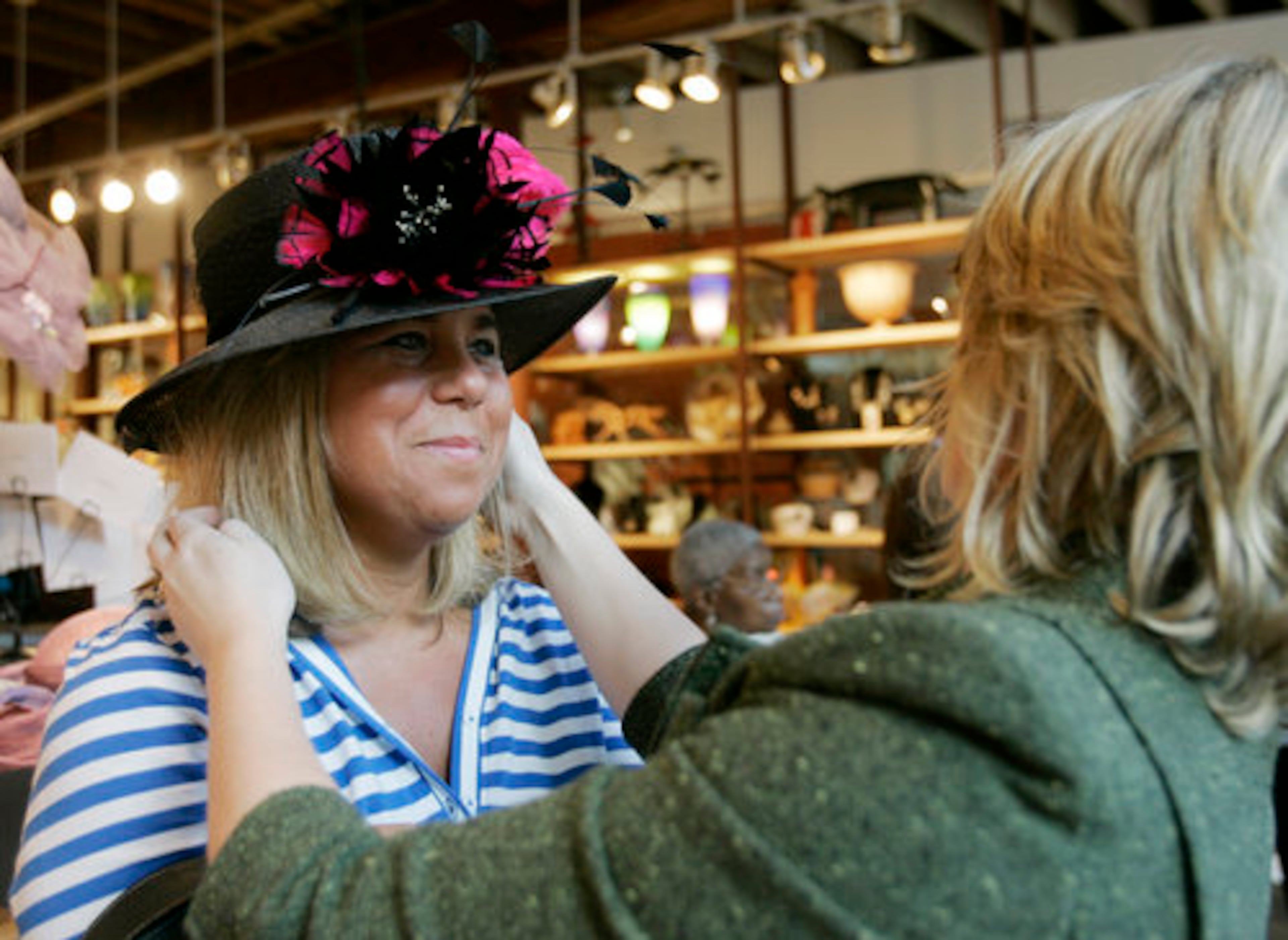 Some of the brightly plumed hats at the Kentucky Derby will be covering up a secret brought on by the lame economy: They're retreads picked from closet shelves, not new finds from fancy boutiques. Some women are looking for bargains. Jane Sprake smiles as hat maker Vicky Hoskinson adjusts her newly decorated hat in Louisville. The makeover cost $70. Sprake sought the makeover for a hat she bought in 2003.