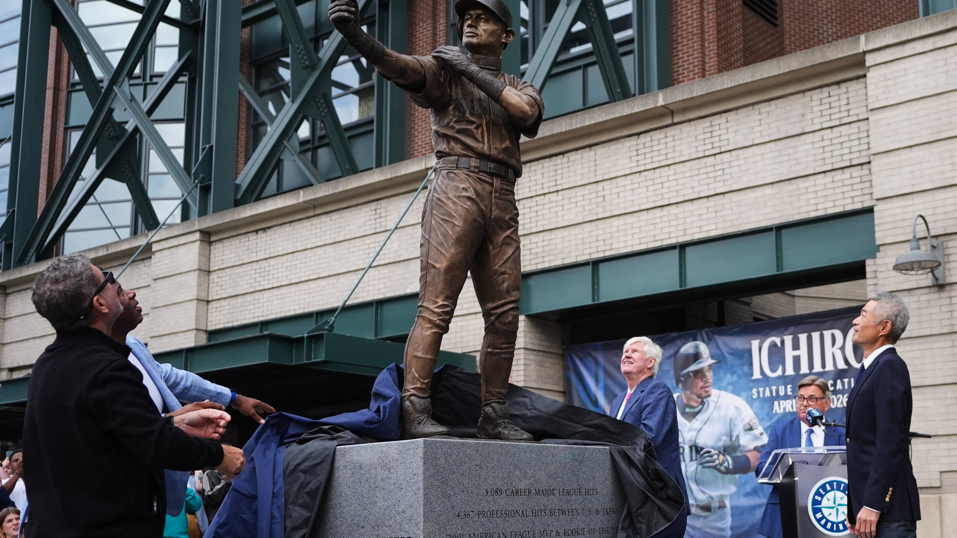 Former Seattle Mariners Edgar Martinez, left, and Ken Griffey Jr., second from left, look on with right fielder Ichiro Suzuki, right, at the broken bat of Ichiro's statue during its unveiling outside of T-Mobile Park, Friday, April 10, 2026, in Seattle. (AP Photo/Lindsey Wasson)