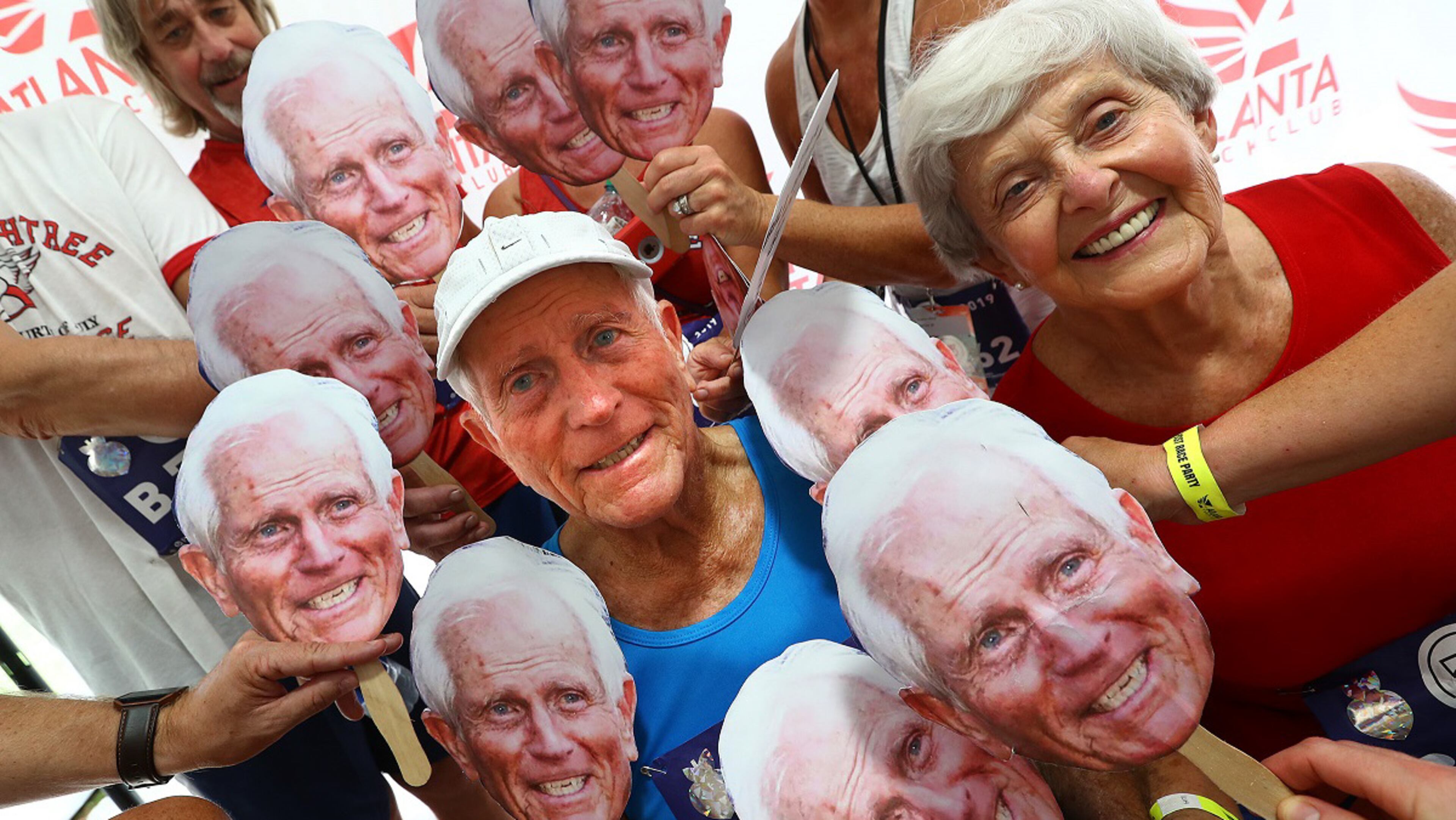 Bill Thorn, 89, and his wife, Patty, are surrounded by family and friends holding his picture at the conclusion of the 50th AJC Peachtree Road Race, having proved enough longevity to have run in every race since the inception. Curtis Compton/ccompton@ajc.com