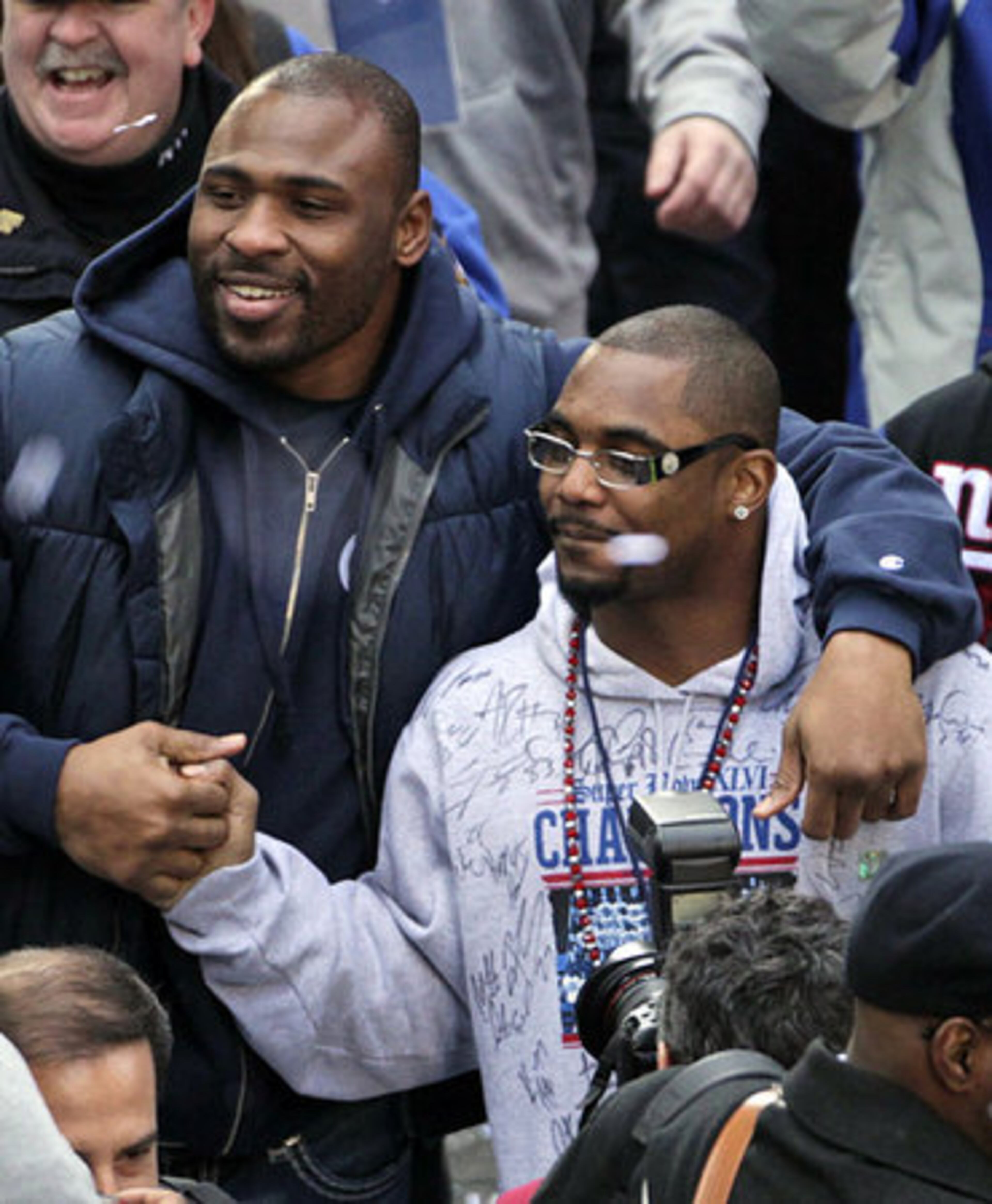 New York Giants' Brandon Jacobs, left, and Ahmad Bradshaw greet fans after jumping off their float during the team's NFL football Super Bowl parade.