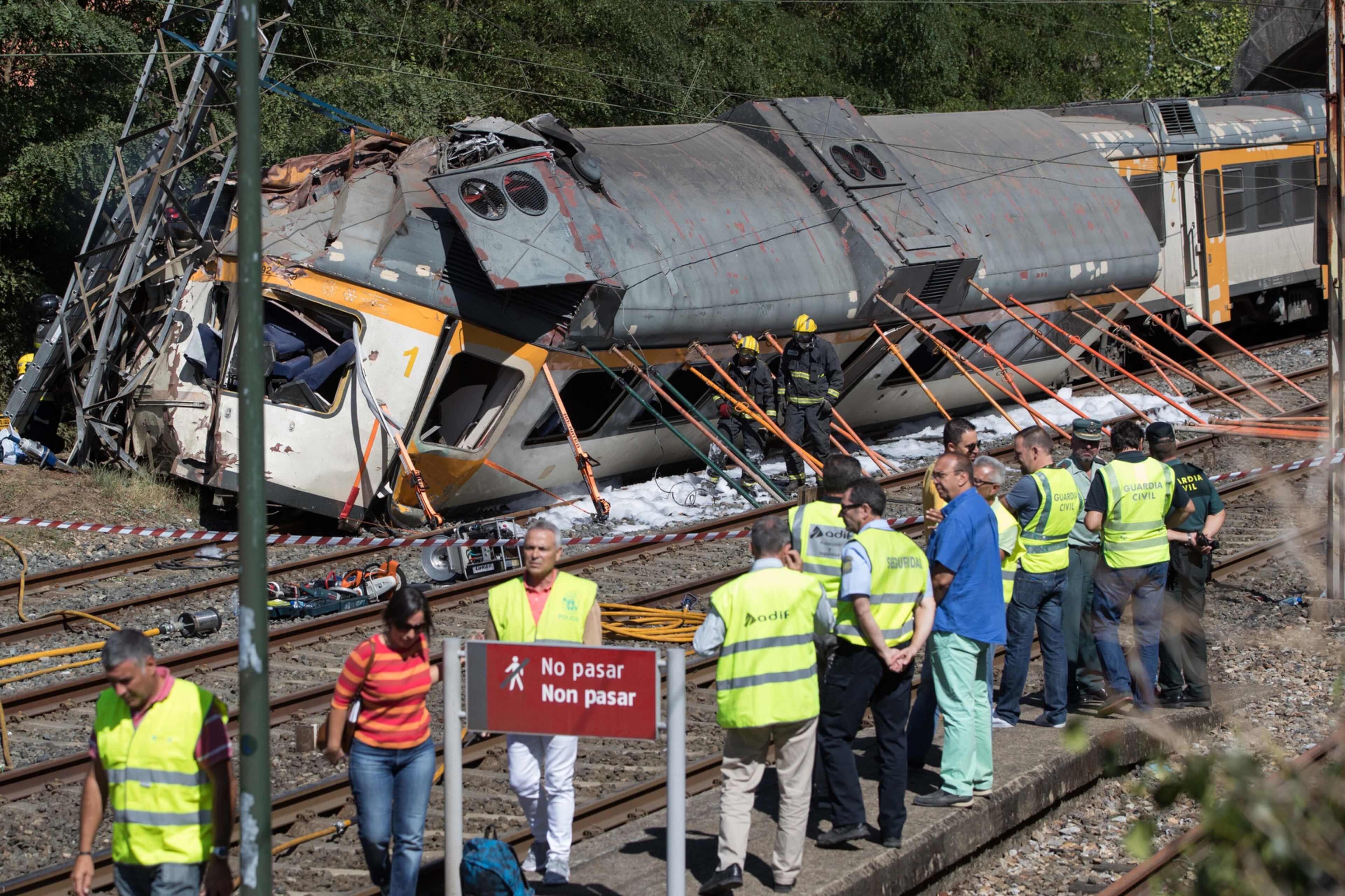 CORRECTS DATE - Emergency personnel attend the scene after a passenger train traveling from Vigo to Porto, in neighboring Portugal, derailed in O Porrino, in Spain's northwestern Galicia region, killing and injuring people, authorities said Friday Sept. 9, 2016. The train had three cars. The front one came completely off the track and hit a post next to the line, leaving it leaning to one side. The back two cars were partly off the tracks. Spanish media said the train was carrying around 60 passengers.(AP Photo/Lalo R. Villar)