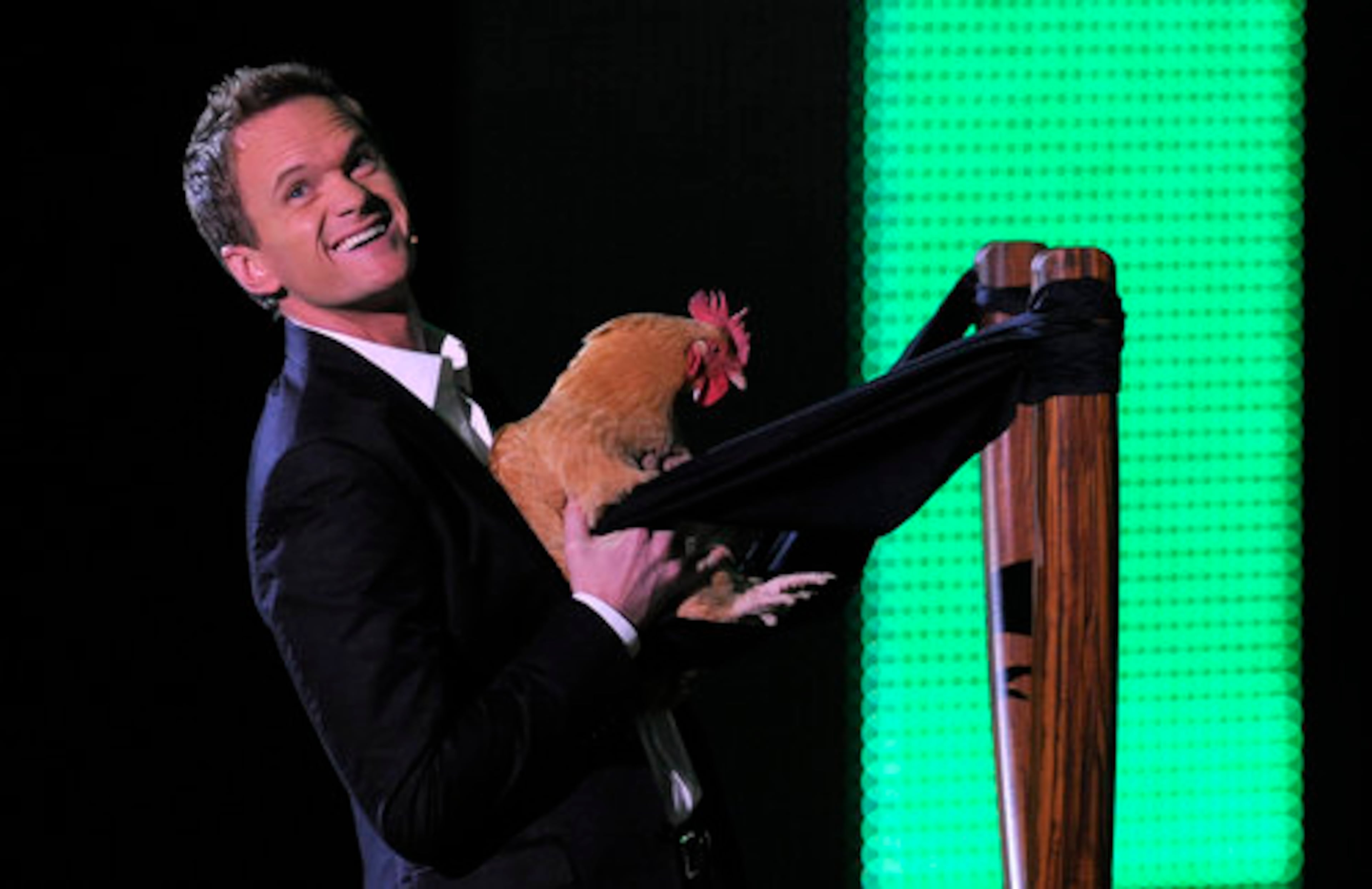 Neil Patrick Harris puts a chicken in a slingshot. Hmmmm, what popular game could he be referencing?
