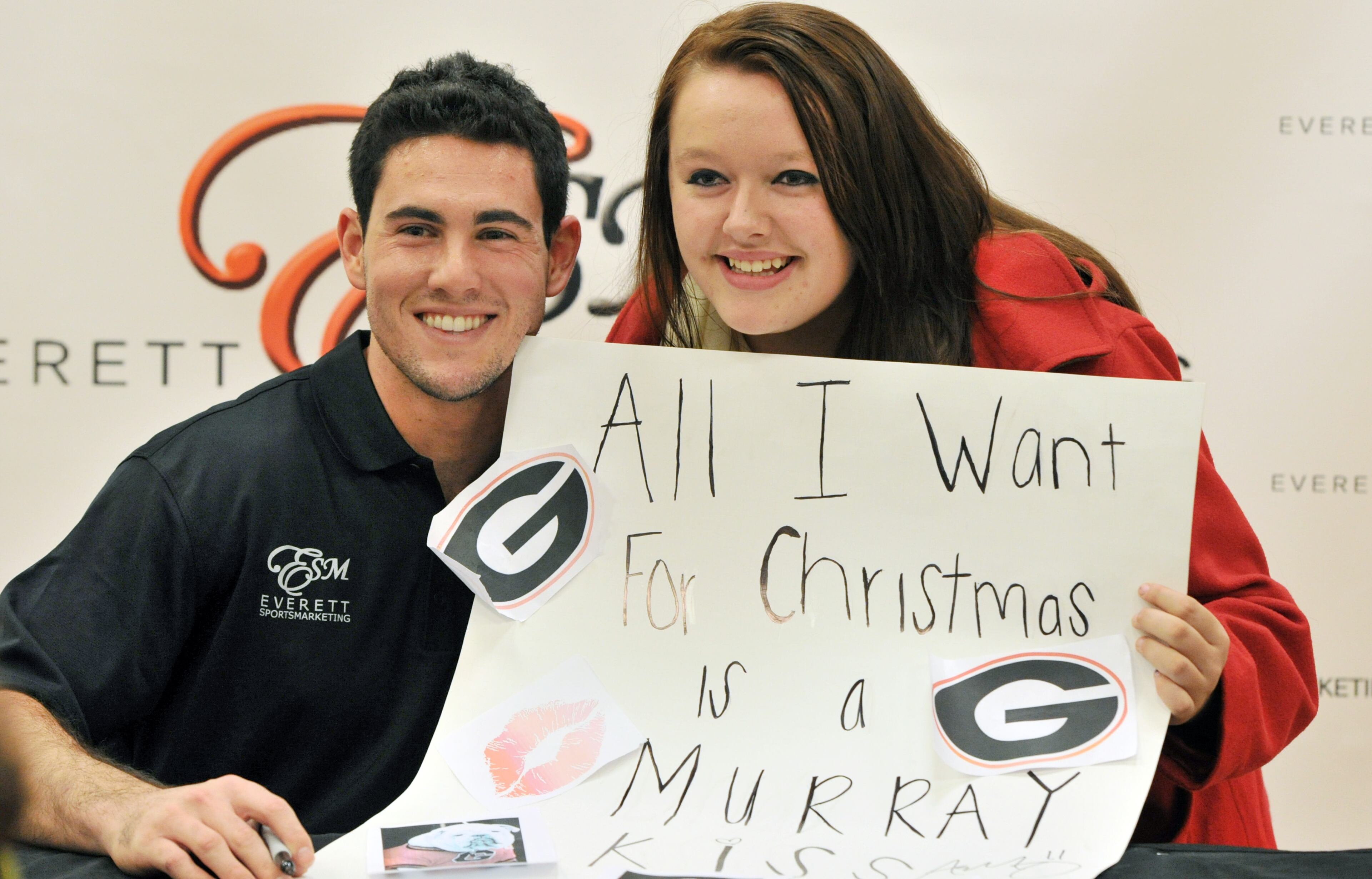 Aaron Murray poses with fan Briana Embrick, of Statham, for a photographer during his signing event at Georgia Square Mall in Athens on Saturday, December 14, 2013. Former Georgia quarterback Aaron Murray is signing autographs at the Georgia Square Mall and part of the proceeds will benefit Extra Special People, an organization that enhances the lives of children with developmental disabilities.