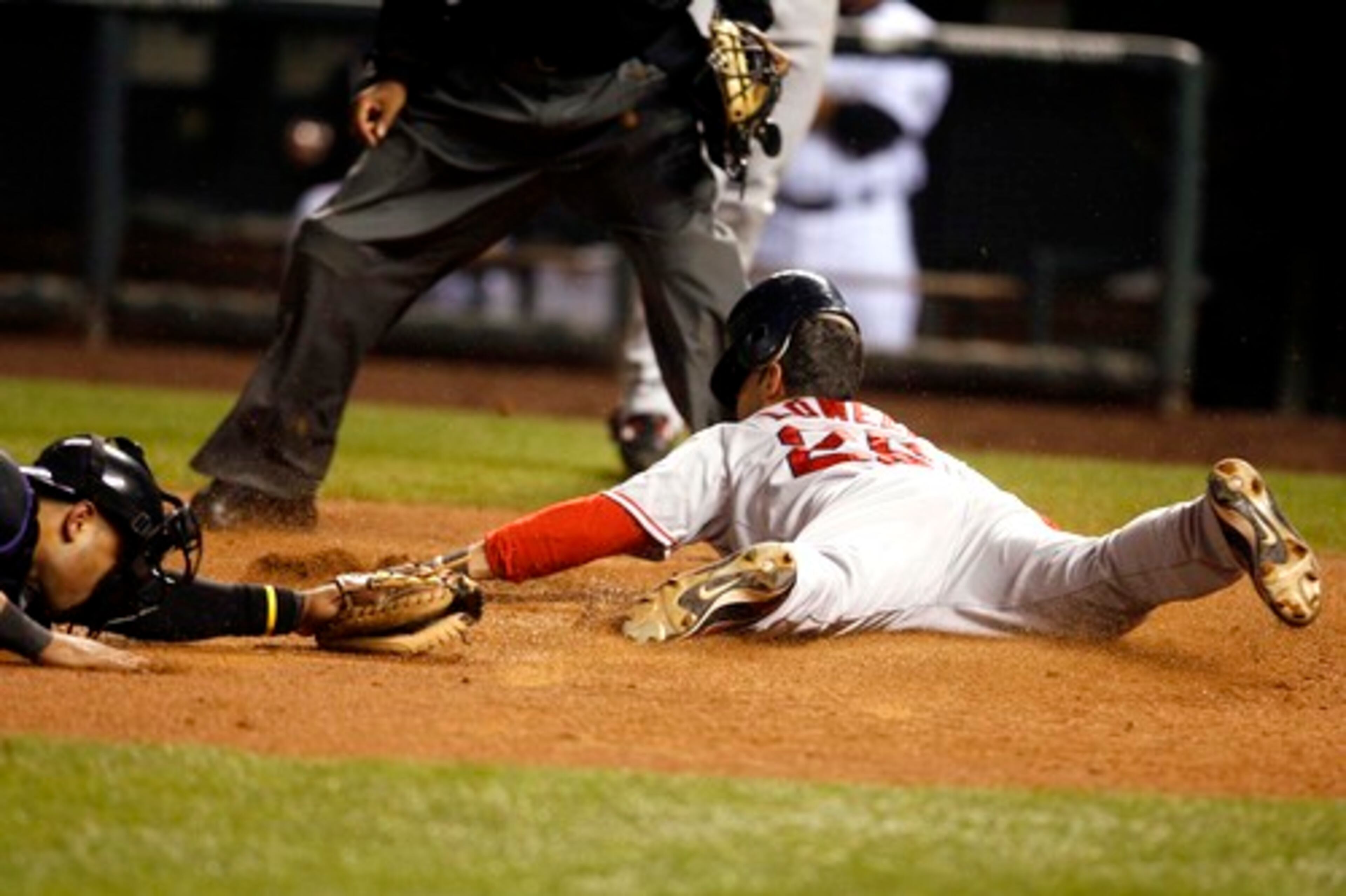 Mike Lowell of the Boston Red Sox, right, slides in safely past the tag of Yorvit Torrealba of the Colorado Rockies. Lowell was named the World Series MVP.