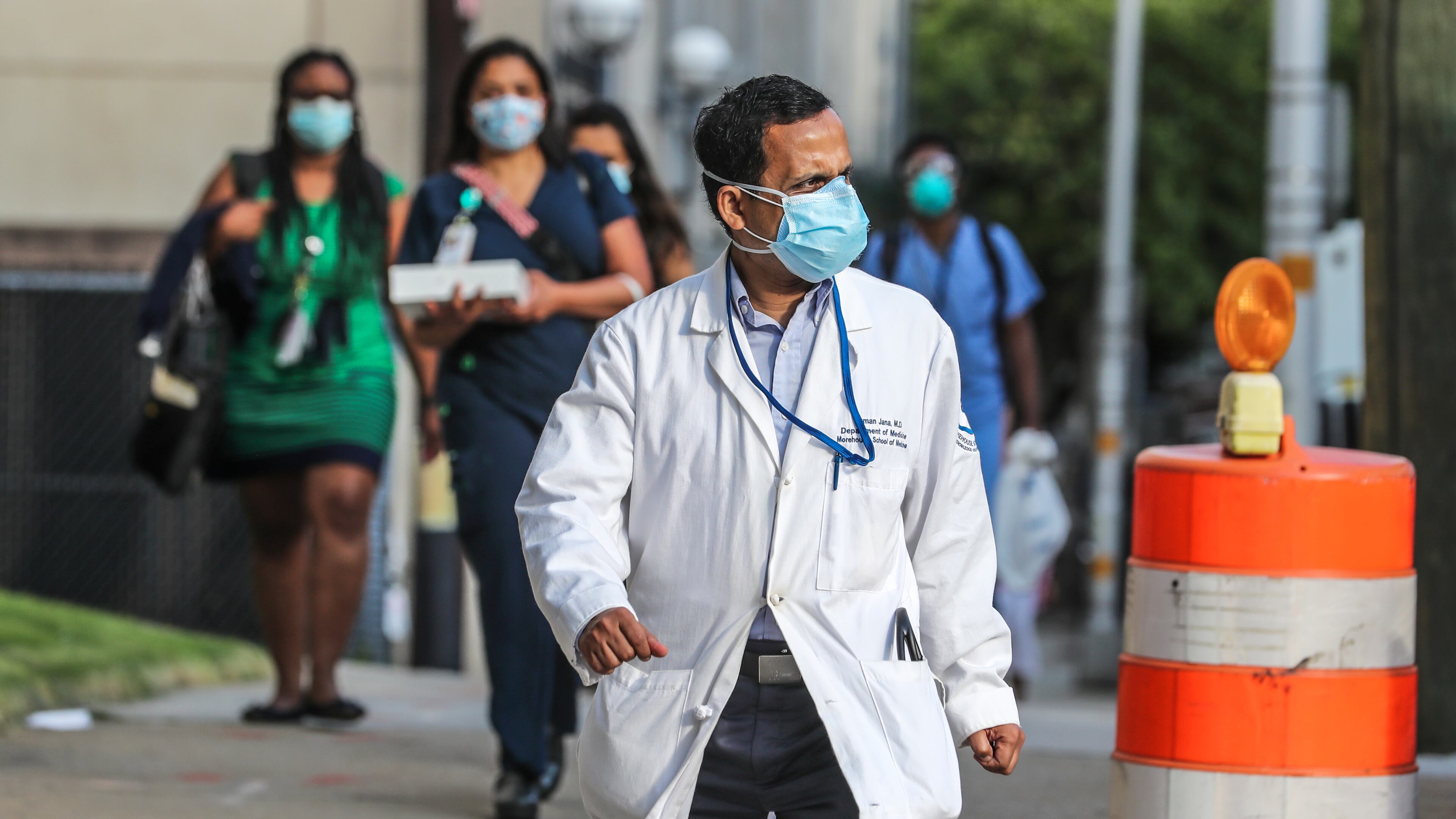 Dr. Suman Jana (foreground) and other medical workers arrived for work at Grady hospital in downtown Atlanta on Aug. 13, a day after the State of Georgia reported more than 100 newly confirmed COVID-19 deaths. The death rate has declined, but on Saturday, the Georgia Department of Public Health said the toll has now exceeded 5,000. JOHN SPINK/JSPINK@AJC.COM