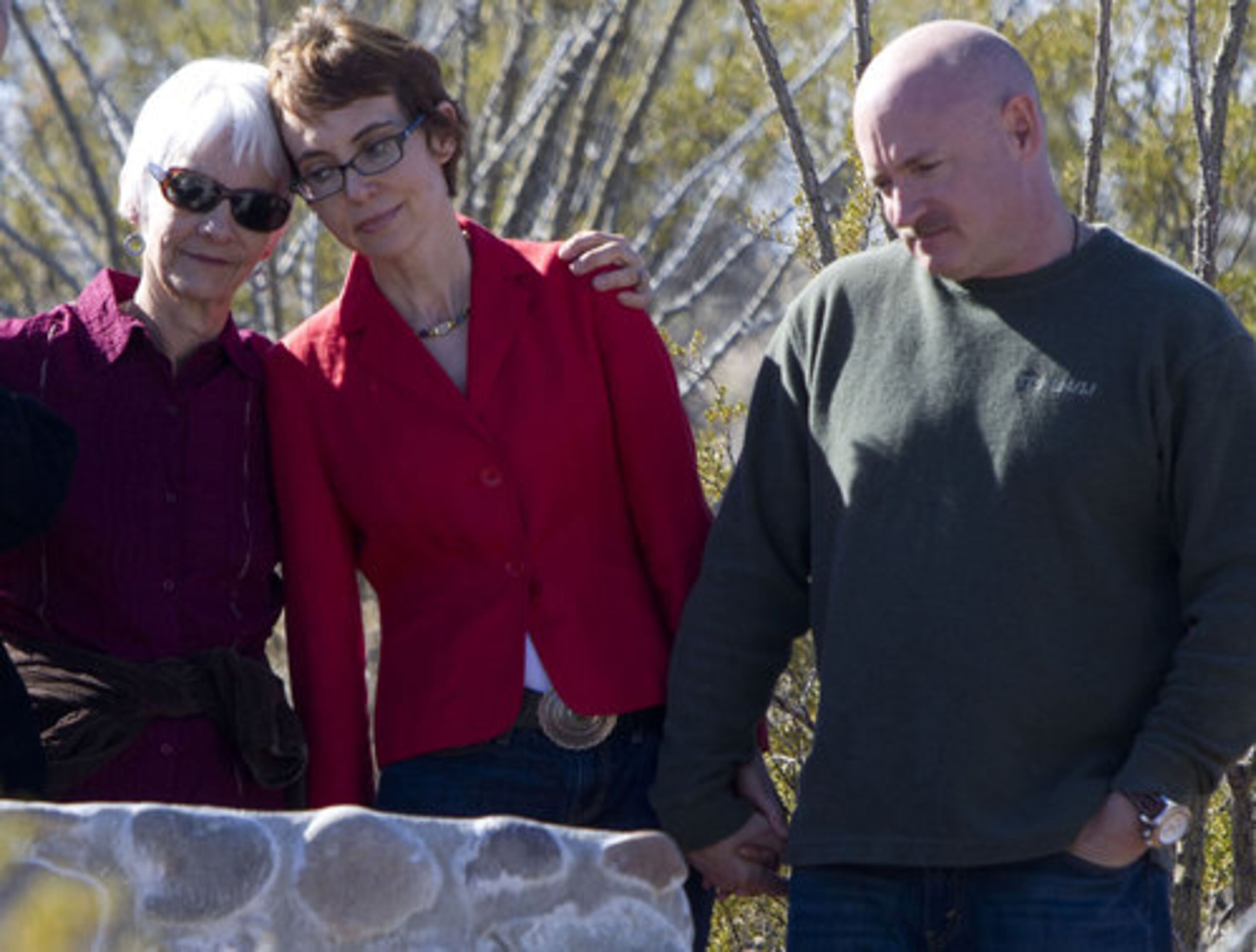 U.S. Rep. Gabrielle Giffords, center, husband Mark Kelly and Nancy Barber, wife of Giffords' district director, Ron Barber, pause at the Davidson Canyon Gabe Zimmerman Trailhead overlooking Tucson, Saturday, Jan. 7, 2012. They're paying tribute to Zimmerman, who was killed almost one year ago during the Tucson shooting. Zimmerman was the director of community outreach for U.S. Representative Giffords.