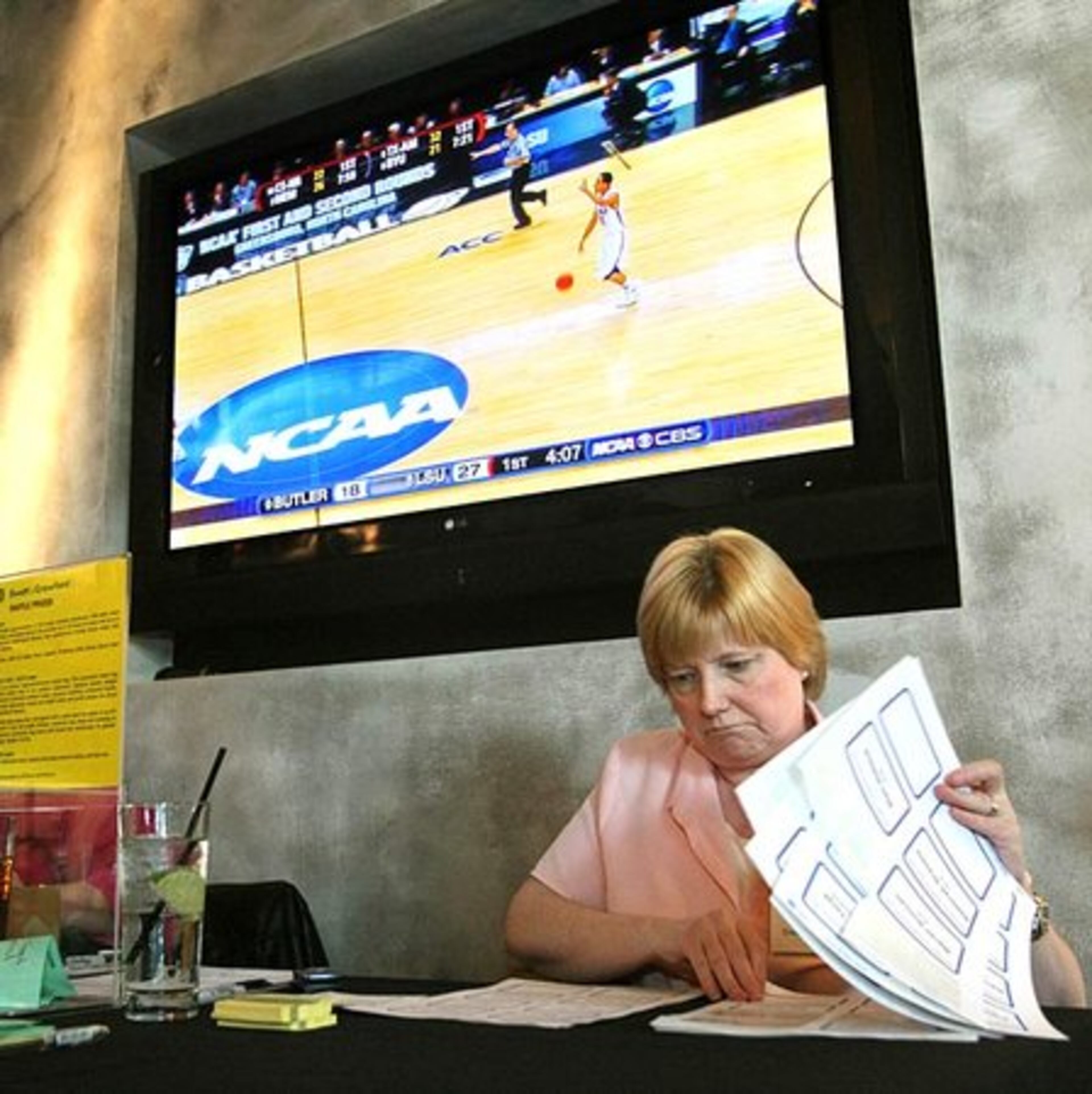 Marianne Christopher, administrative assistant with insurance broker Swett & Crawford, looks over the guest nametags at the entrance to their private party for employees and clients at Stats.