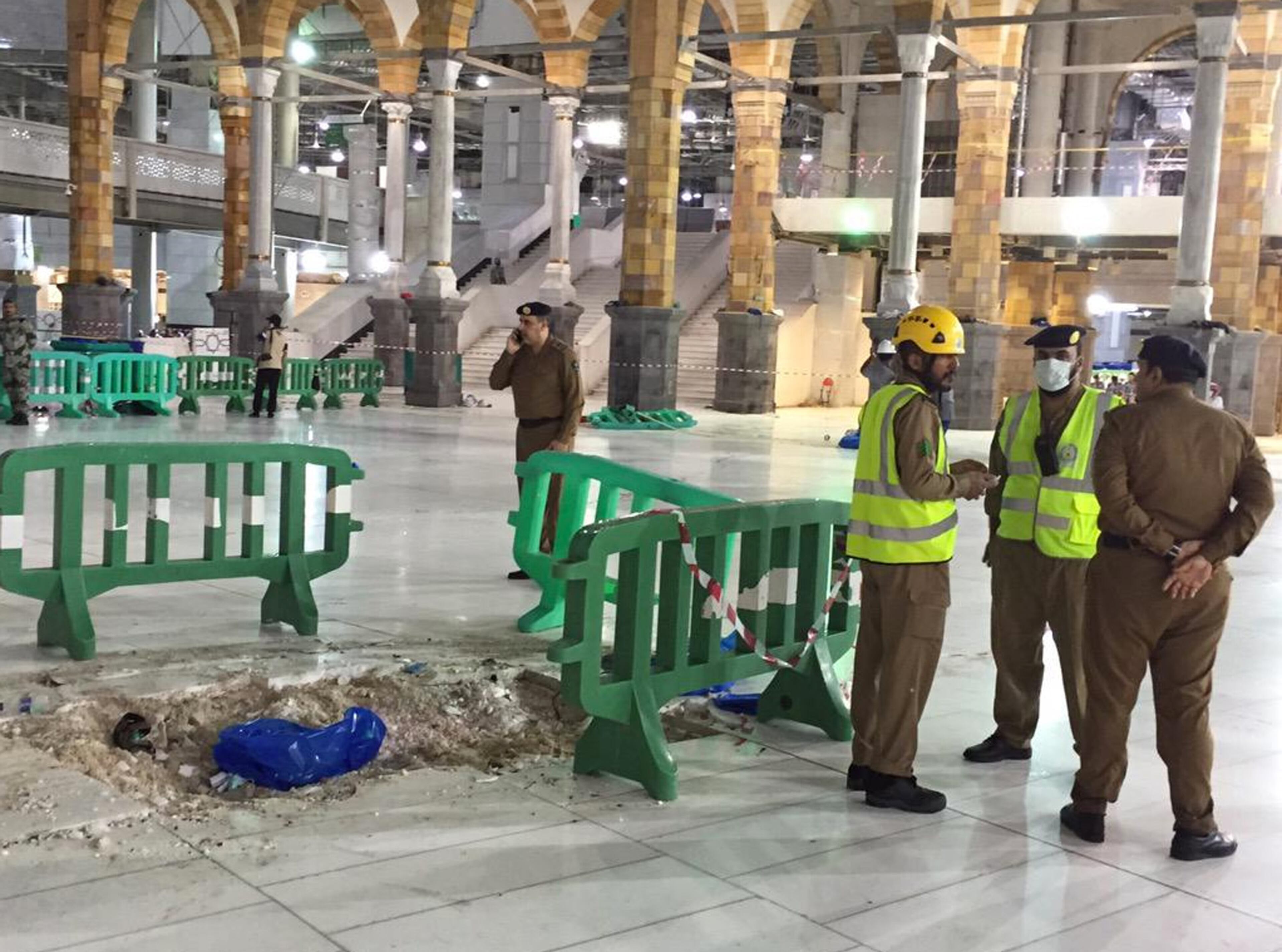 In this image released by the Saudi Interior Ministry's General Directorate of Civil Defense, Civil Defense officials inspect the damage at the Grand Mosque in Mecca after a crane collapsed killing dozens, Friday, Sept. 11, 2015. The accident happened as pilgrims from around the world converged on the city, Islam's holiest site, for the annual Hajj pilgrimage, which takes place this month. (Saudi Interior Ministry General Directorate of Civil Defense via AP)