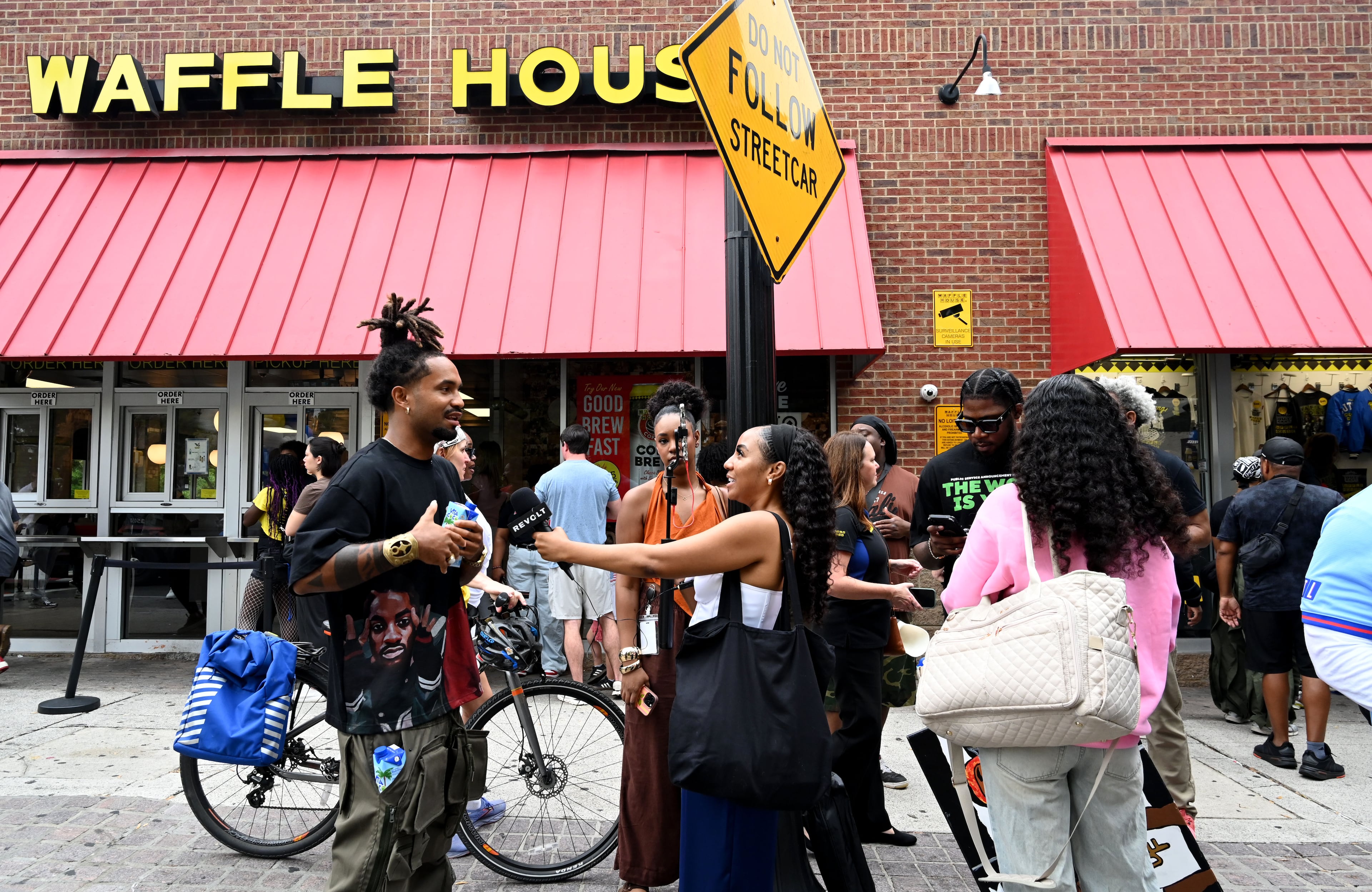 Social media influencers interview people who purchased limited-edition apparel and accessories from the Outkast and Waffle House collaboration launch event. (Hyosub Shin/AJC)