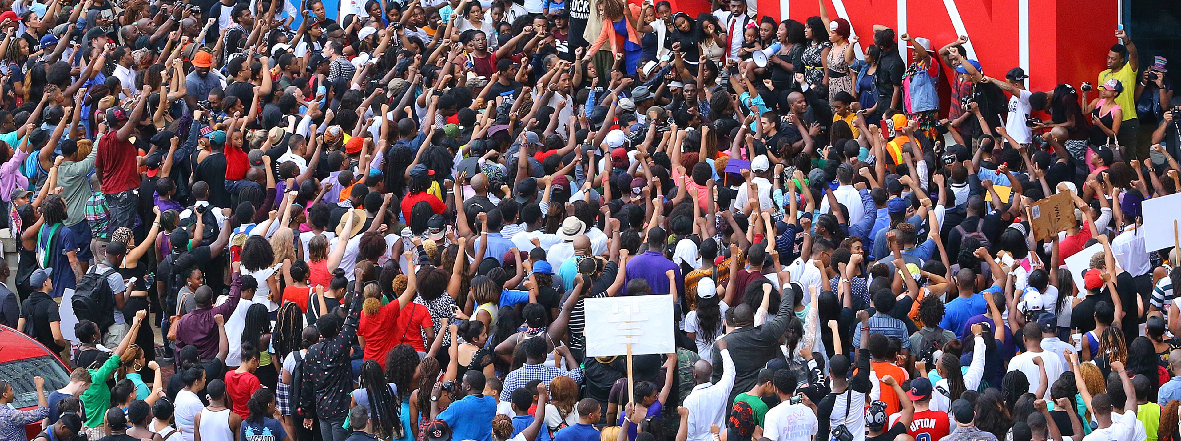 081814 Atlanta: Protesters raise their fists in the air shouting " no justice no peace" during a rally for Mike Brown and Ferguson outside the CNN Center on Monday, August 18, 2014, in Atlanta. CURTIS COMPTON / CCOMPTON@AJC.COM