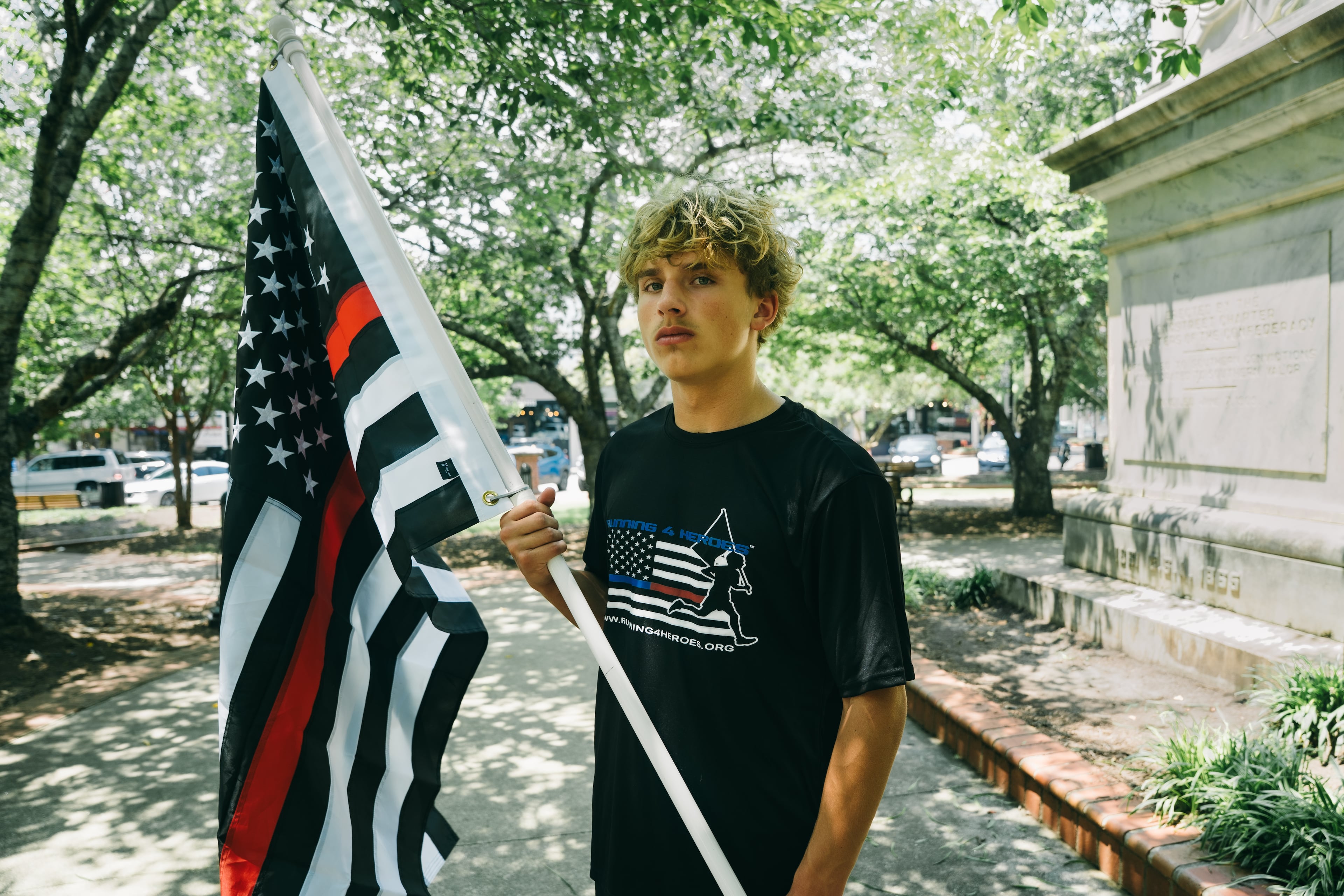 Andrew Collinson, 16, poses for a portrait in the Gainesville Square July 30, 2026, the day before he undertakes his final run for the nonprofit Running 4 Heroes Inc. Collinson has run over 130 miles for the organization, honoring first responders whose lives have been lost in service (Olivia Bowdoin for the AJC).