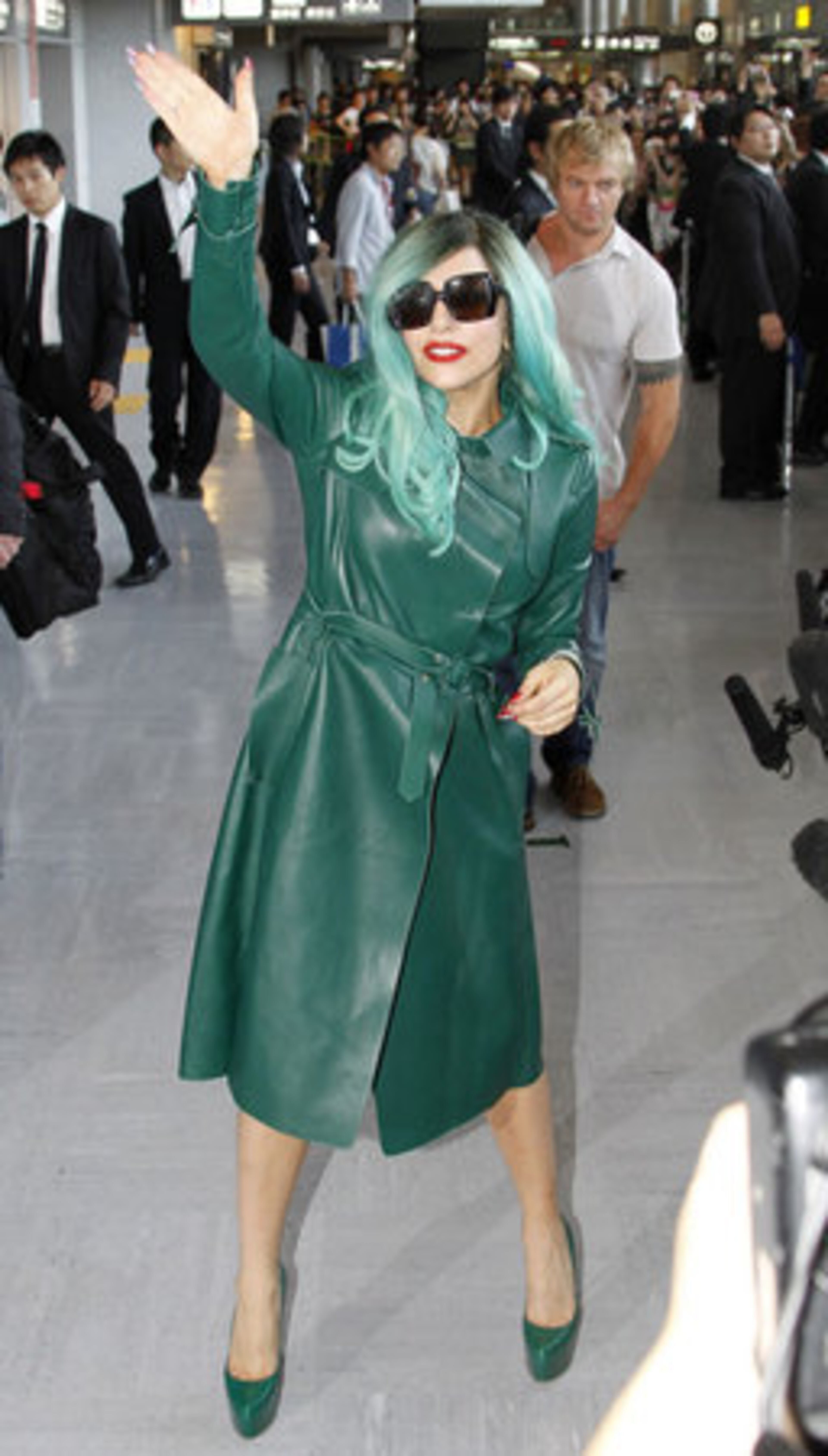 Lady Gaga, dressed in green from head to toe, waves to fans as she arrives in Japan.