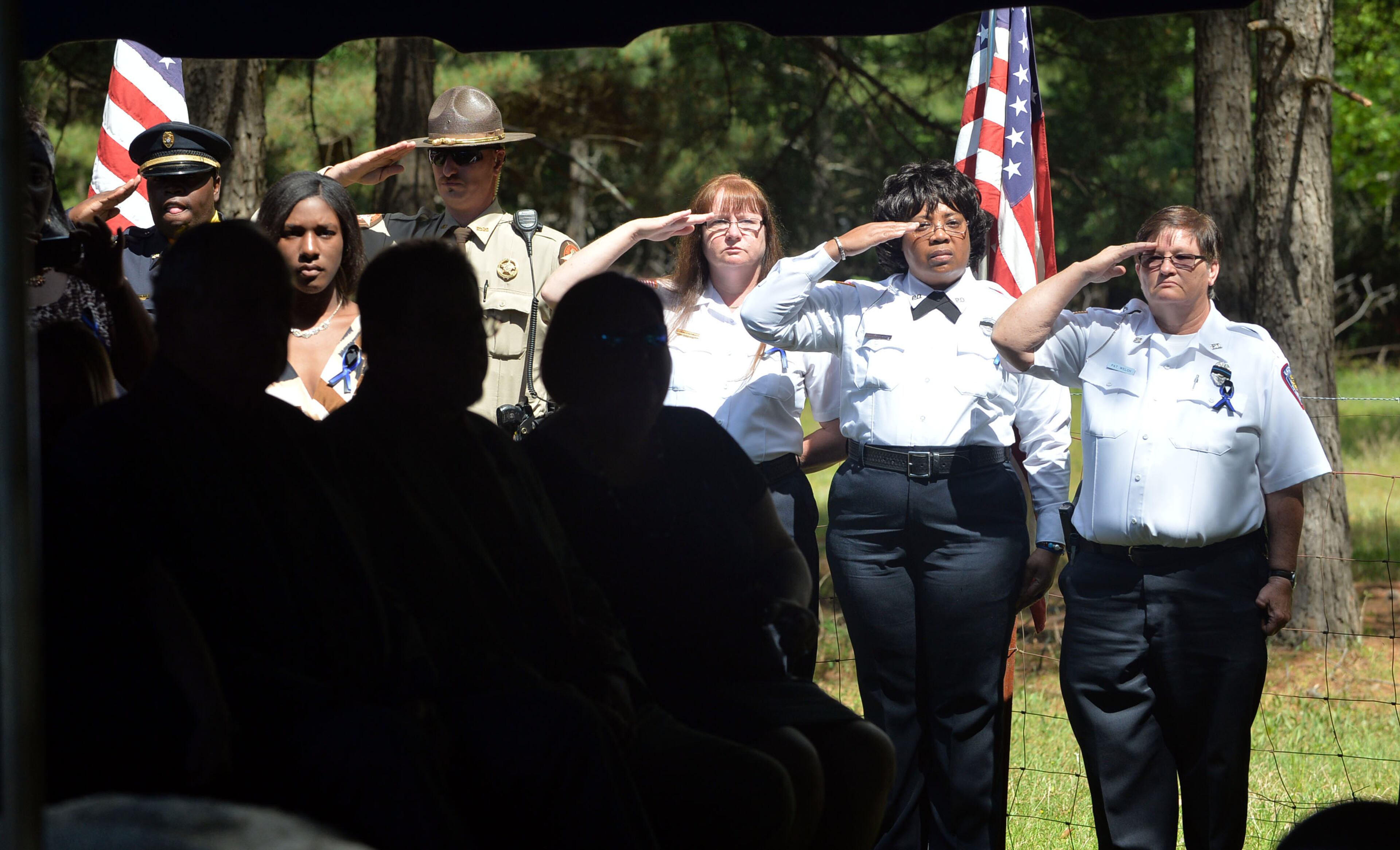 Officers salute as "Taps" is played at the A.E. Carter Funeral Home in Madsion, Ga.