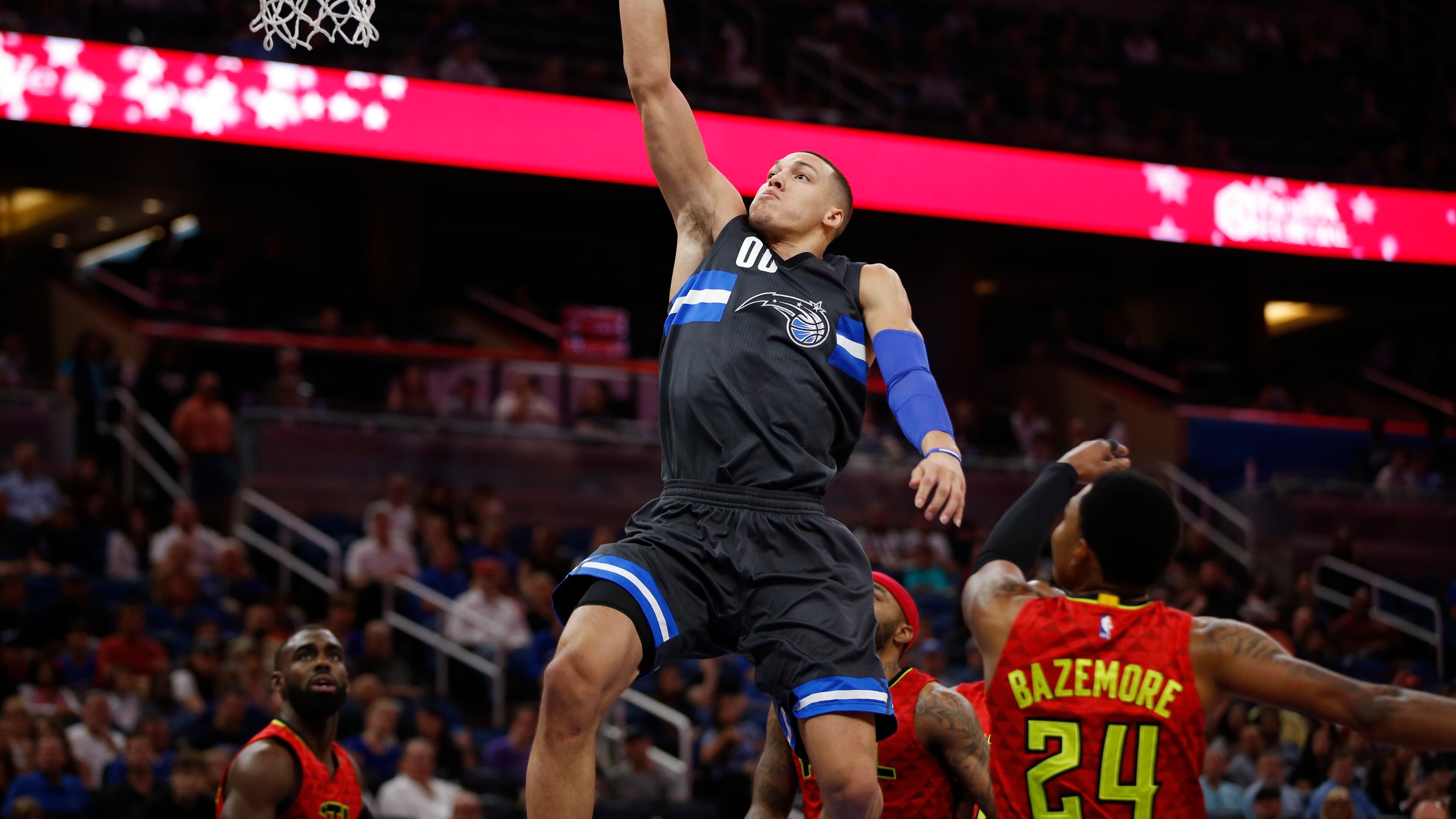 Orlando Magic forward Aaron Gordon dunks over Hawks forward Kent Bazemore in the first quarter of a game Saturday night in Orlando. (AP photo)