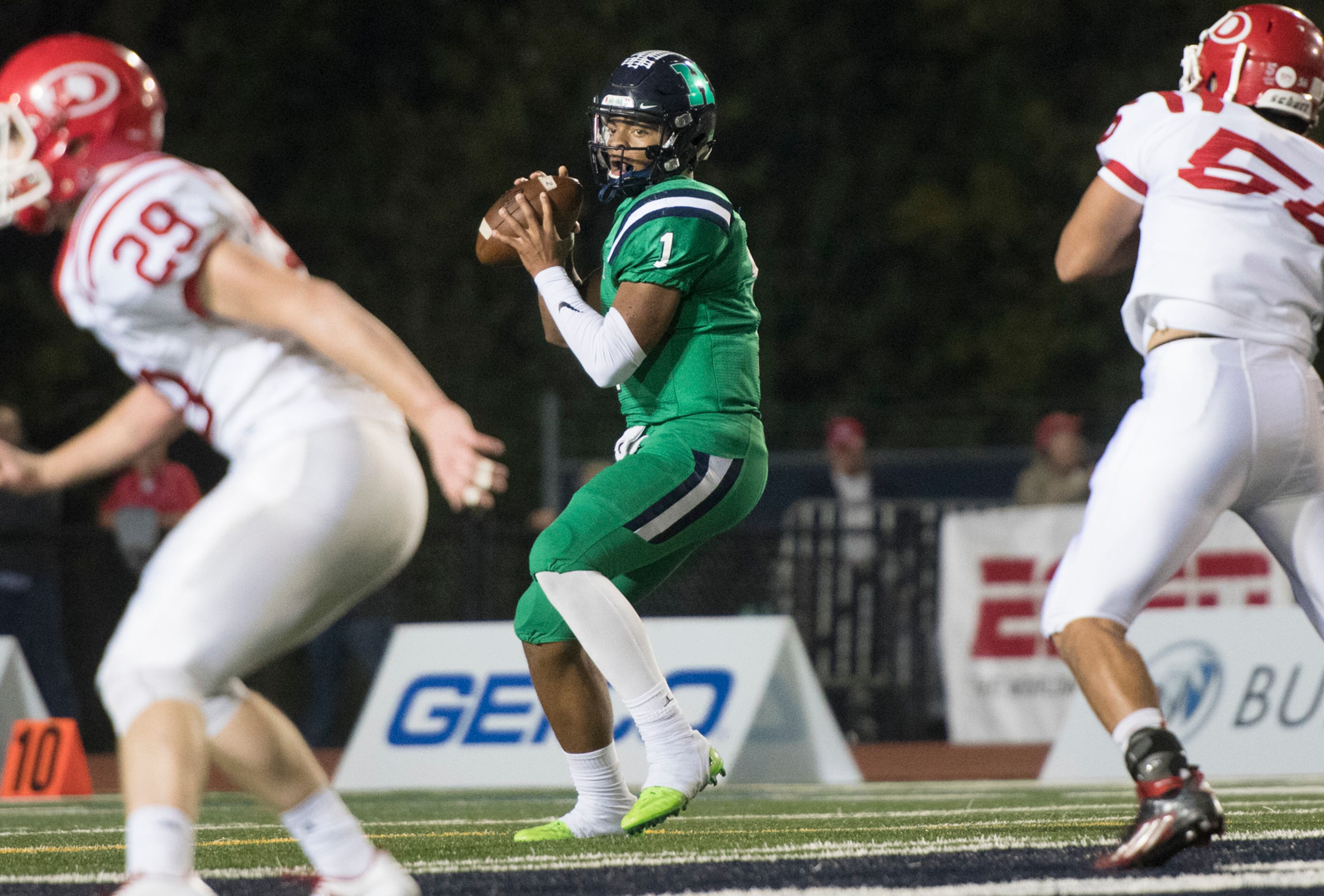 Harrison quarterback Justin Fields (1) drops back to pass as Dalton defensive end Kevin Diaz (56) and linebacker Jack Ridley (29) defend during a high school football game on Thursday, Oct. 19, 2017, in Kennesaw, Ga. (Special to the Atlanta Journal-Constitution, John Amis )