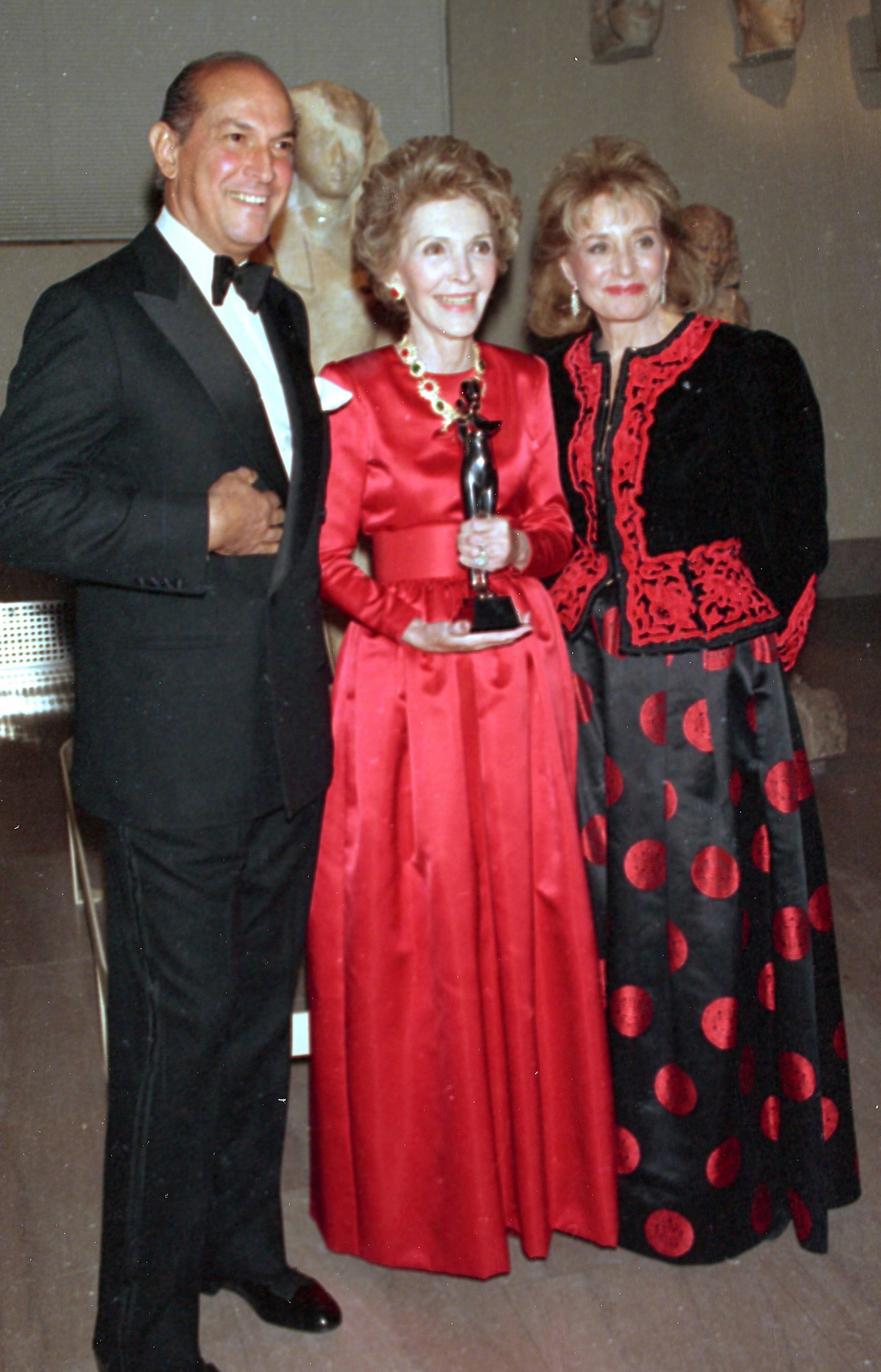 This Jan. 10, 1989 file photo shows fashion designer Oscar de la Renta, left, and journalist Barbara Walters, right, posing with first lady Nancy Reagan at the Metropolitan Museum of Art in New York City. The first lady was awarded the Council of Fashion Designers of America's Lifetime Achievement Award for her contributions to fashion. The award was presented by Walters during a ceremony at the museum. Sure, living in the White House has its perks. But a clothing allowance is not one of them. First ladies feel all sorts of pressure to project a fashionable look, and over the decades they�ve tried a range of cash-saving strategies to pull it off without going broke. Seven frugal do�s _ and don�ts _ that first ladies have tried over the years: Mrs. Reagan was criticized by some for wearing borrowed designer clothes, sometimes without returning them or reporting them as gifts. (AP Photo/Ed Bailey, File)