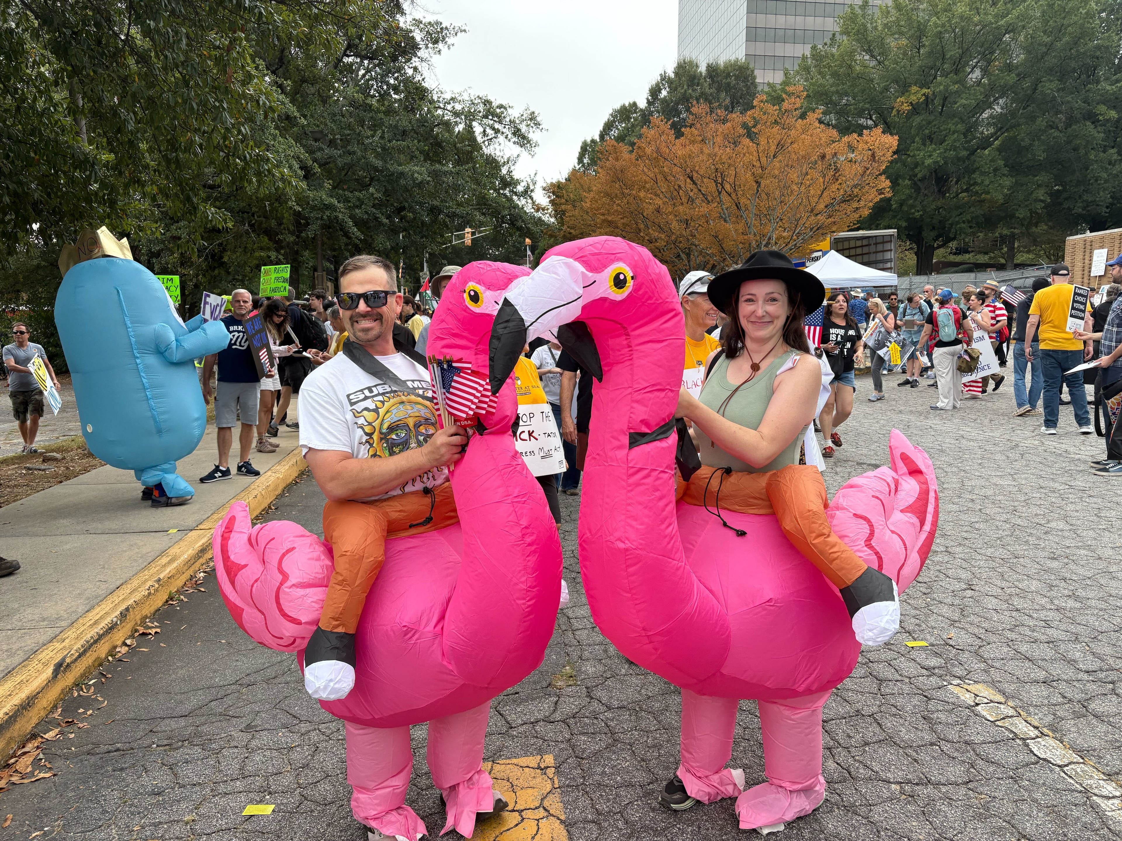 Husband and wife Joshua and Tamara Kilburg came from Winder dressed as flamingos to attend the protest. They said they were opposed to the Trump administration’s policies on immigration and reproductive rights, among other issues. (Shaddi Abusaid/AJC)