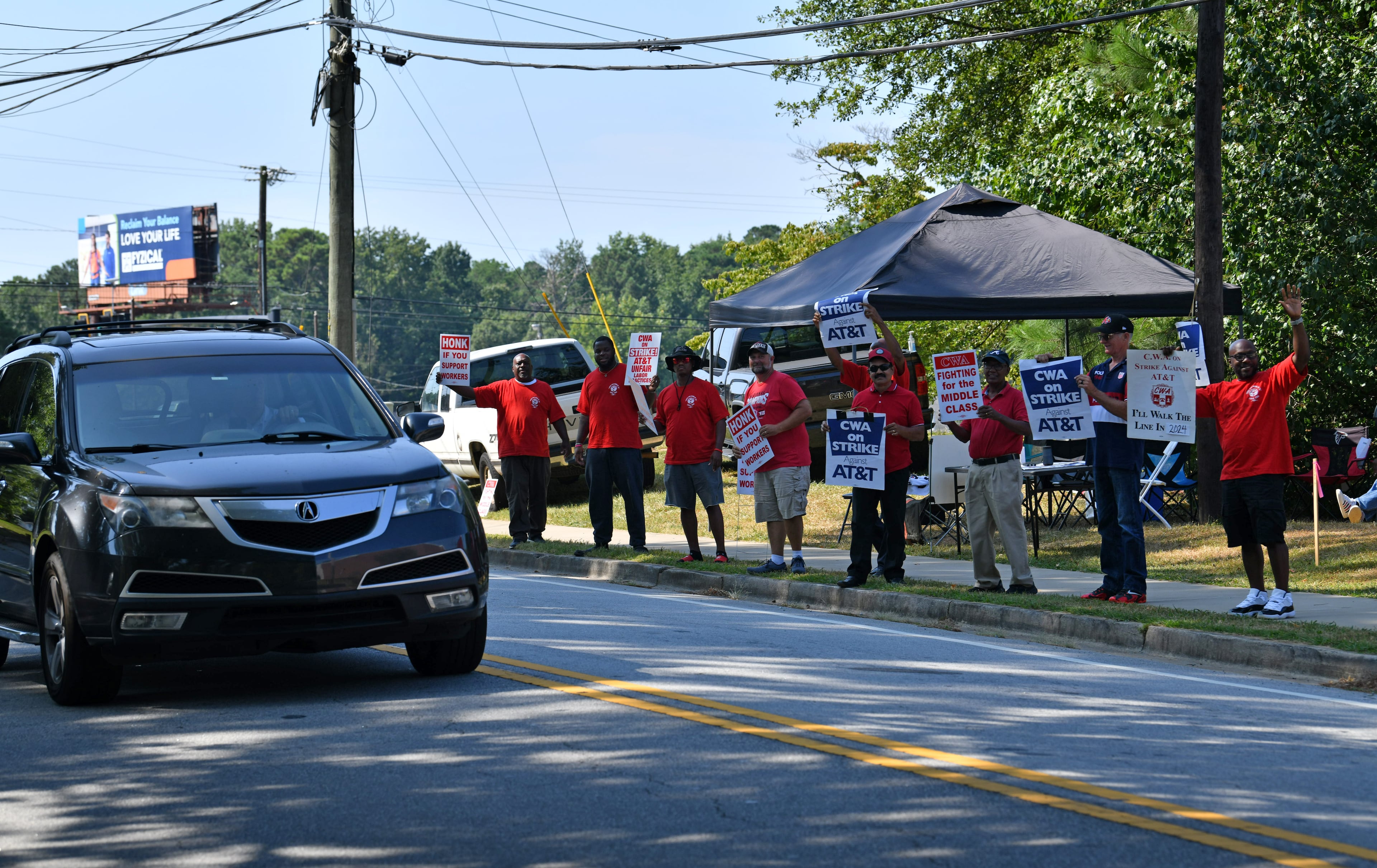 Striking AT&T workers hold signs outside AT&T facility on Brockett Road, Friday, Aug. 30, 2024, in Tucker. Some 17,000 AT&T workers in Atlanta and across the Southeast are on strike, having walked off their jobs on Aug. 16 amid an impasse in contract negotiations. (Hyosub Shin / AJC)