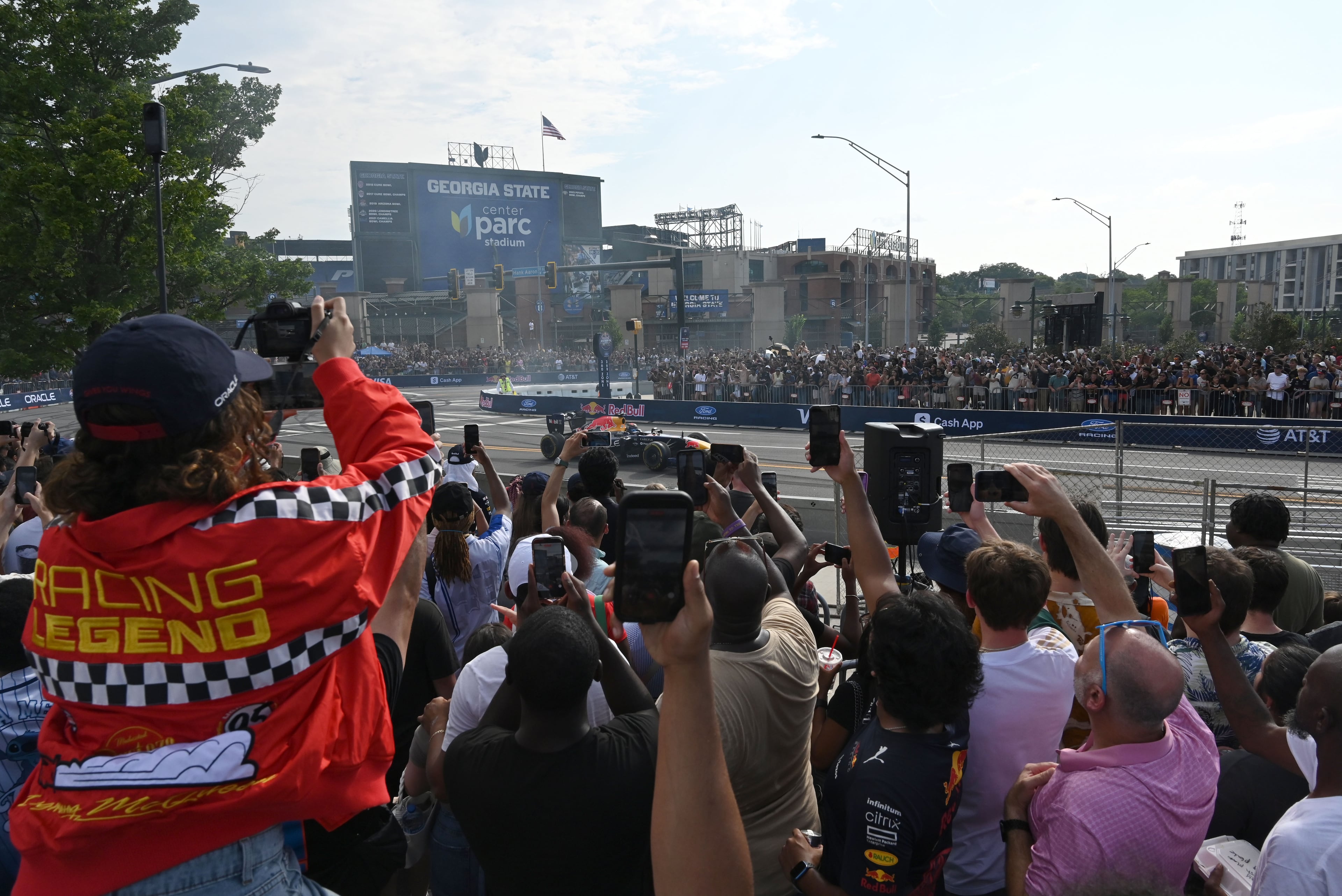 Spectators hold up their smartphones to capture a demonstration run on Hank Aaron Drive during the Red Bull Showrun Atlanta Presented by Ford Racing on Saturday, Aug. 1, 2026, in Atlanta. Atlanta city officials this week approved permits for the Red Bull Showrun that will allow the live motorsports demonstration event to go on as advertised along a roughly half-mile stretch of Hank Aaron Drive — a backup location after earlier plans to hold the event near Piedmont Park ran into opposition from Midtown residents. (Hyosub Shin/AJC)