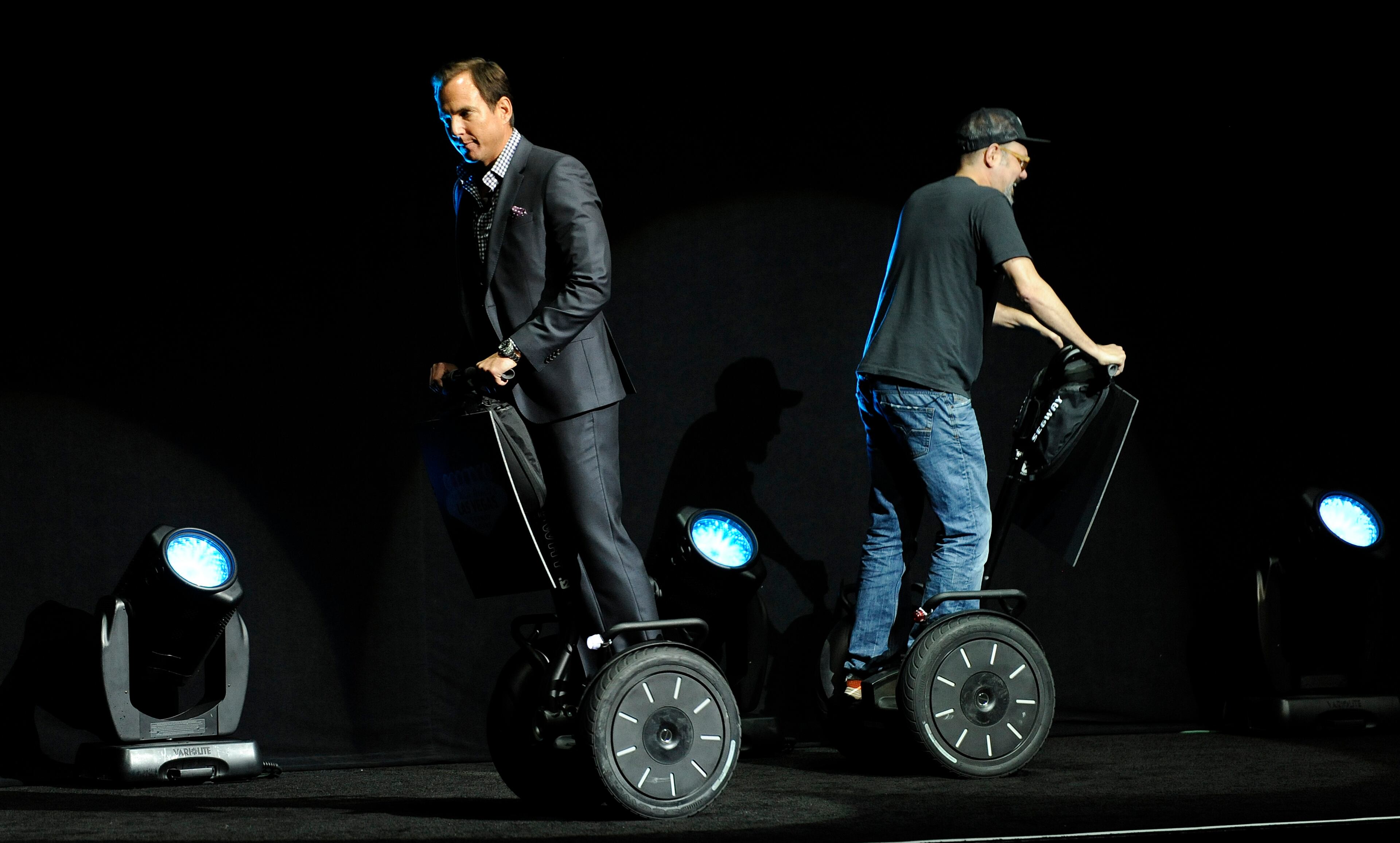 Will Arnett, left, and David Cross, cast members in the upcoming film "Teenage Mutant Ninja Turtles," ride Segways onstage before introducing a clip from the film at the Opening Night Presentation from Paramount Pictures at CinemaCon 2014 on Monday, March 24, 2014, in Las Vegas. (Photo by Chris Pizzello/Invision/AP)