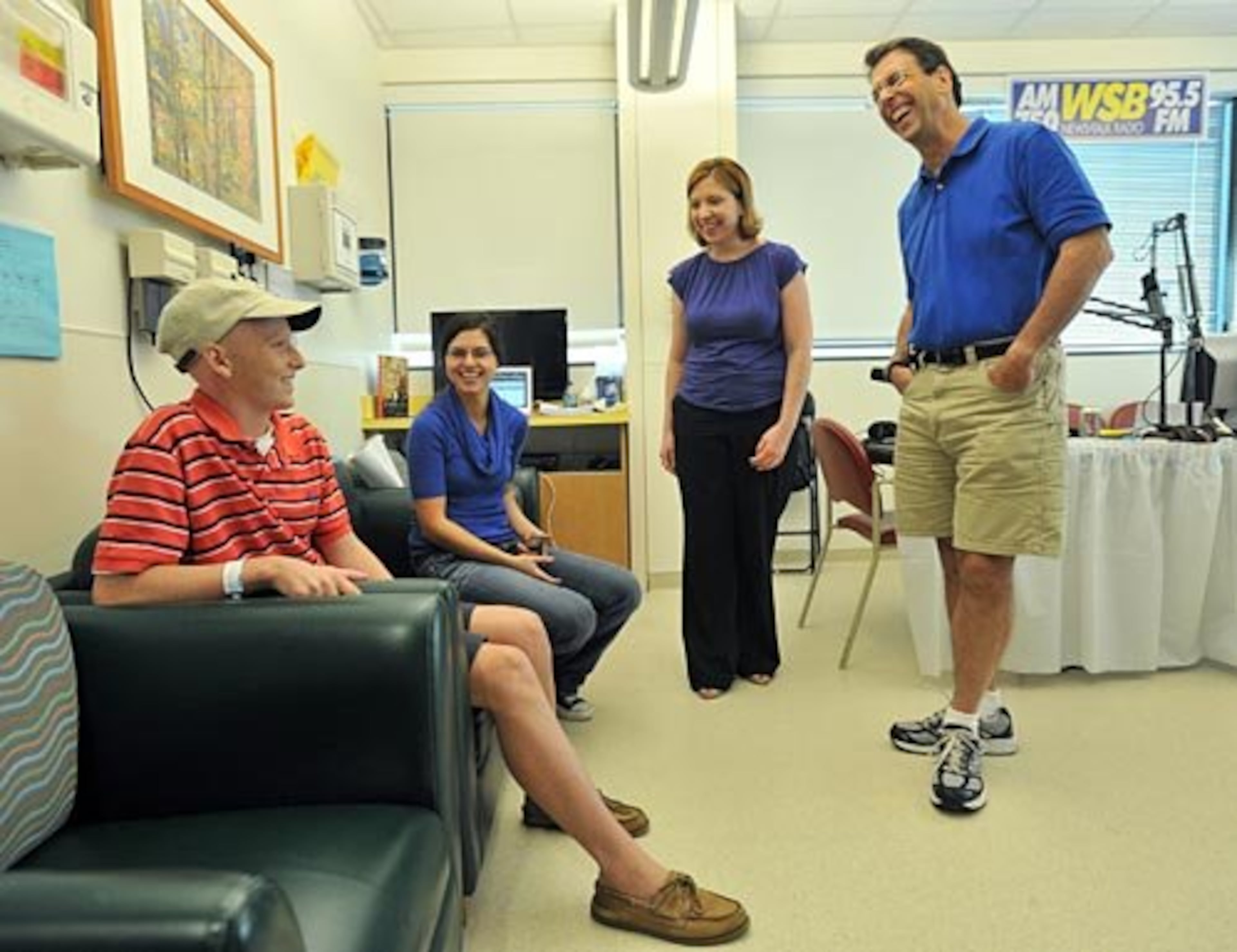Clark Howard (right) talks with patient Christopher Dobson (left), 16, who has been diagnosed with Hodgkin's Lymphoma as Faith Robinson (second from left), associate producer of HLN, and Christa DiBiase, executive producer of The Clark Howard Show on WSB-AM, listen.
