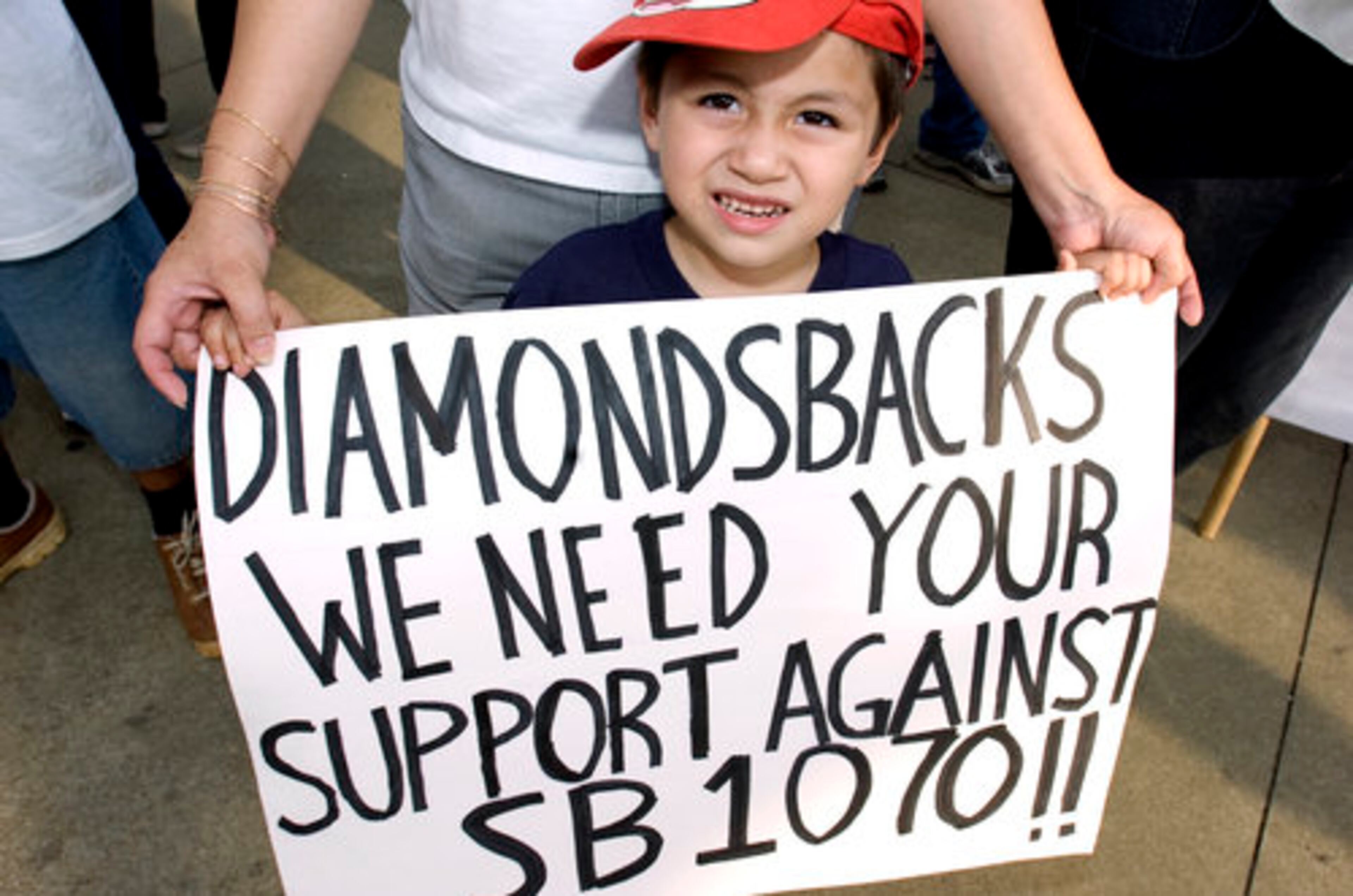 Wanda Hernandez of Gwinnett -- with her three-year-old son Kevin -- protested outside Turner Field just before the Atlanta Braves and the Arizona Diamondbacks played on Saturday. Arizona's recent anti-immigration law is SB 1070.