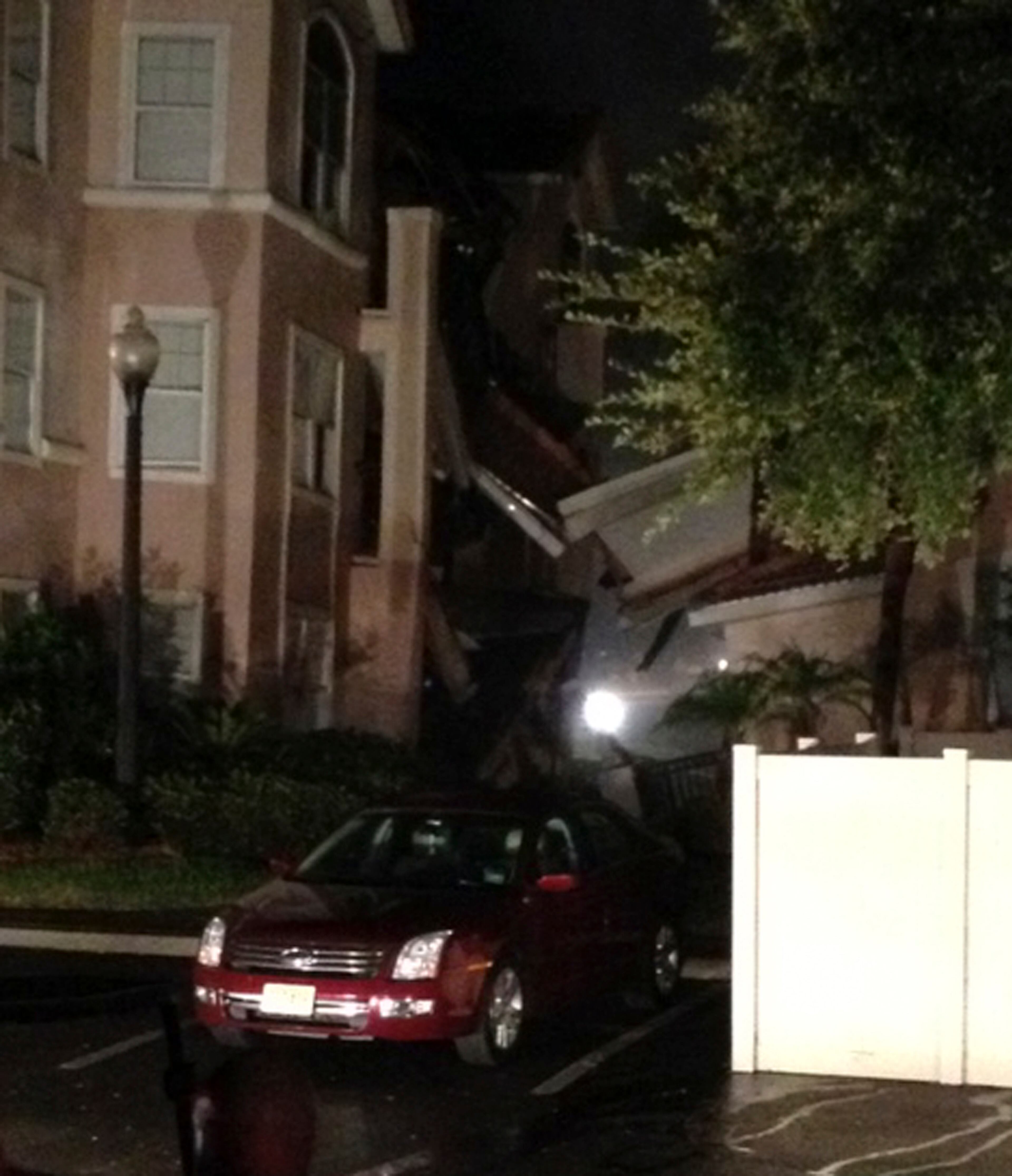 In this video frame grab image taken from WFTV television, a car is parked in front of a partially collapsed hotel building after its foundation cracked in Clermont, Fl., early Monday, Aug. 12, 2013. A sinkhole caused a section of a central Florida resort villa to partially collapse early Monday, while another section of the villa was sinking, authorities said. About 30 percent of the three-story structure collapsed around 3 a.m. Monday, Lake County Fire Rescue Battalion Chief Tony Cuellar said. No injuries were reported. (AP Photo/WFTV/Myrt Price)