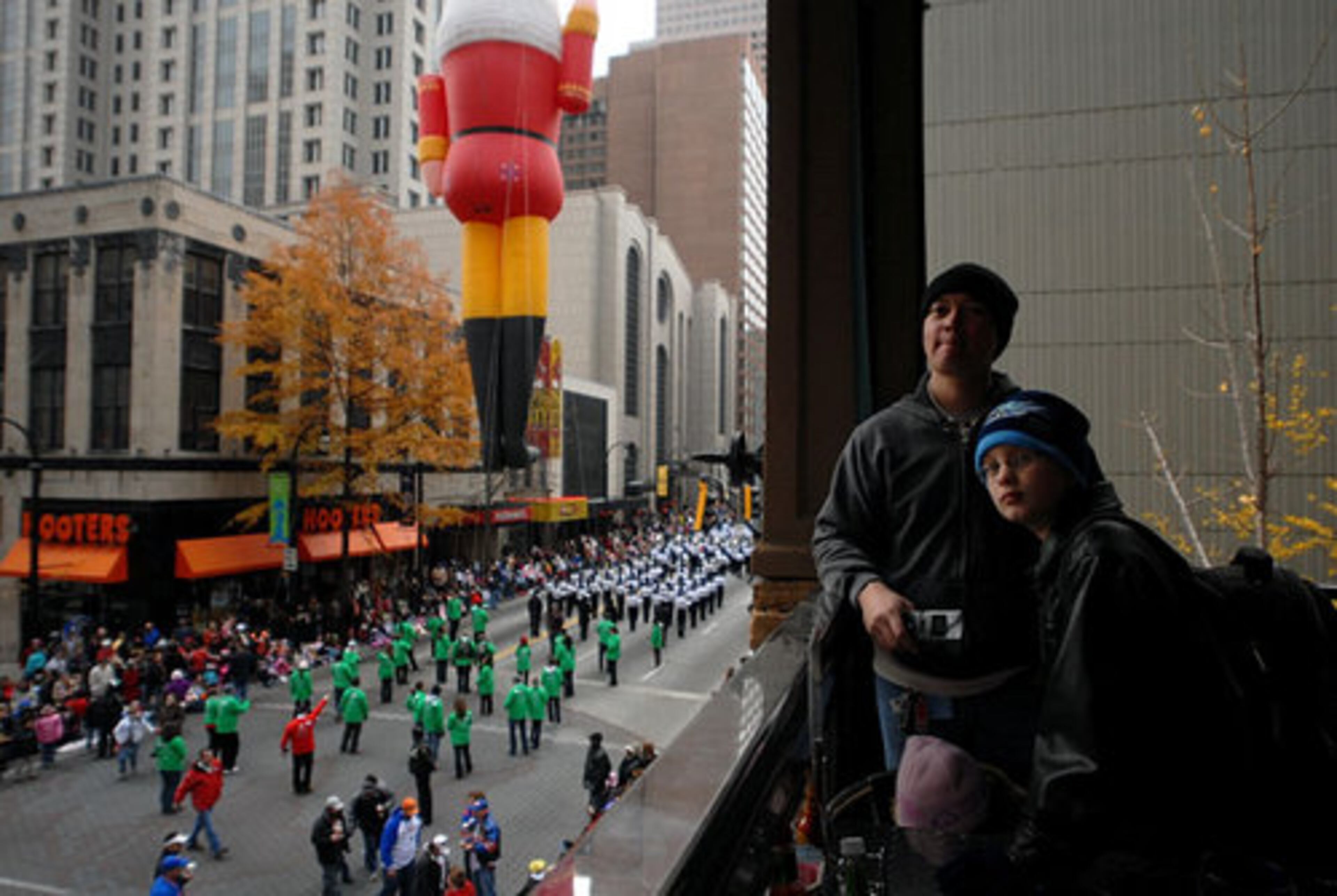 Apollo Cabrera, of Powder Springs, and his son, Antonio, 9, and daughter, Olivia, 2, watch the parade from the Jalapeno Charlie's restaurant balcony.
