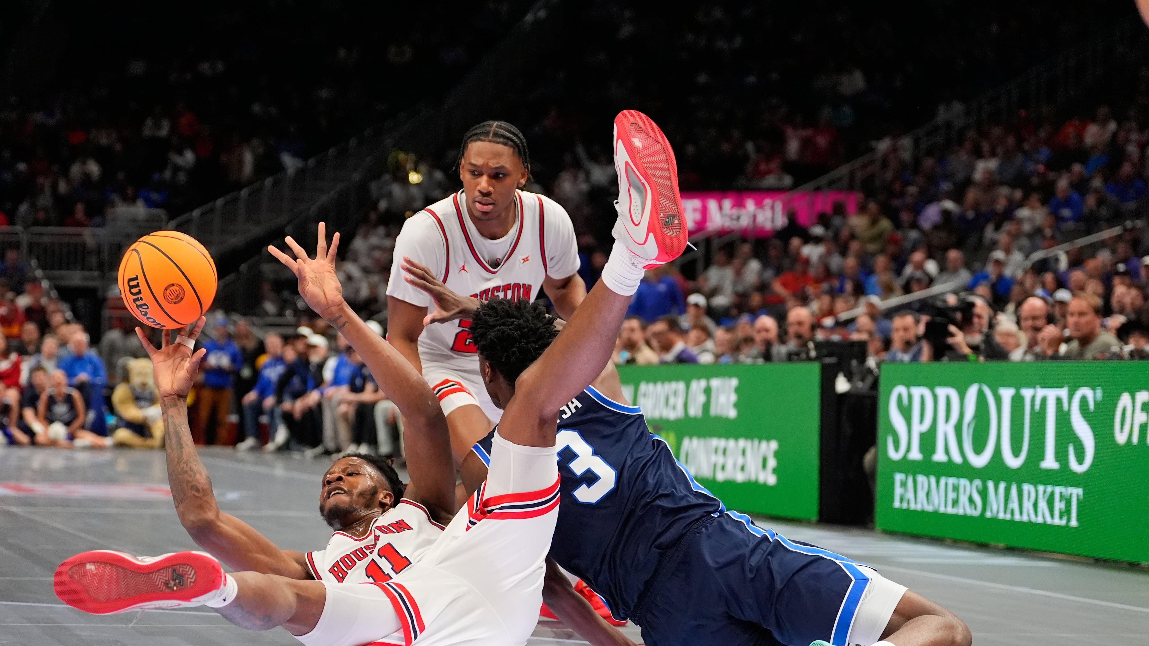Houston's Joseph Tugler (11) passes as BYU's AJ Dybantsa (3) defends during the first half of an NCAA college basketball game in the quarterfinal round of the Big 12 Conference tournament Thursday, March 12, 2026, in Kansas City, Mo. (AP Photo/Charlie Riedel)
