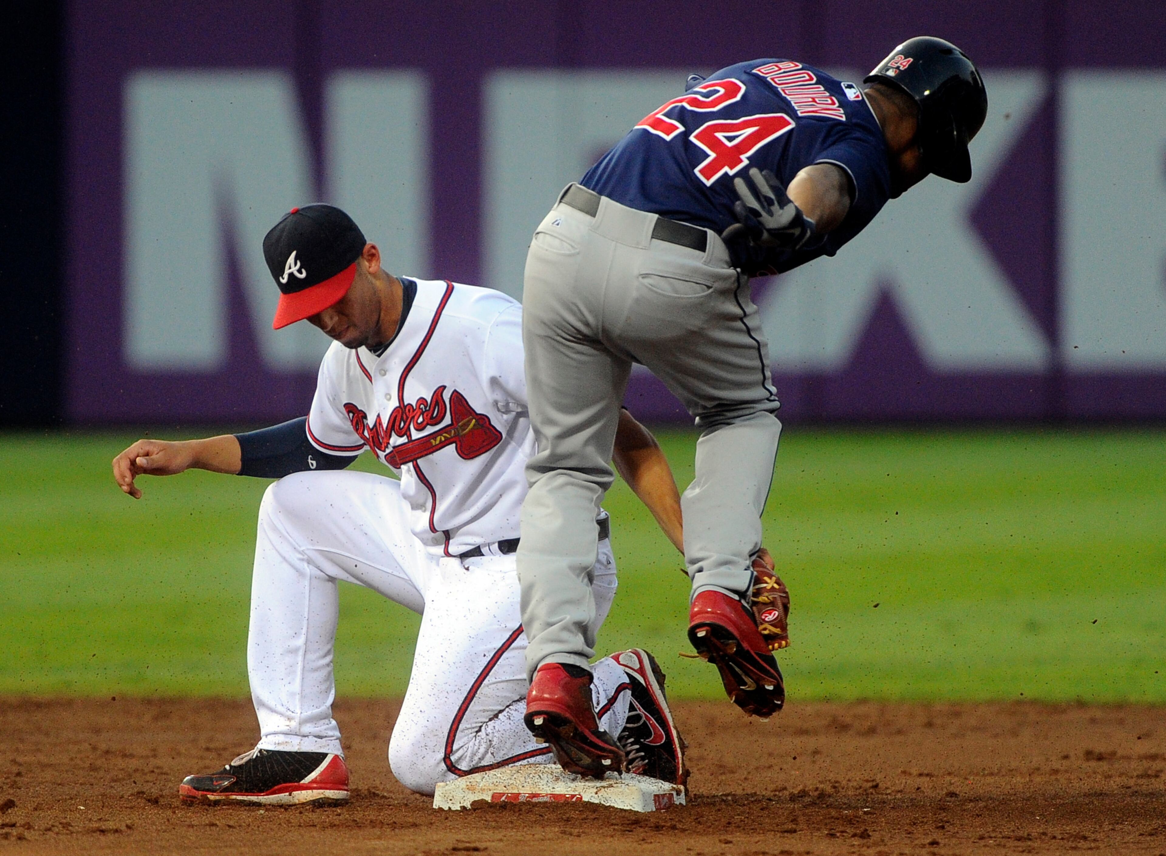 Atlanta Braves shortstop Andrelton Simmons, left, is late on the tag on Cleveland Indians' Michael Bourn who steals second base during the third inning of a baseball game on Thursday, Aug. 29, 2013, in Atlanta. (AP Photo/John Amis)