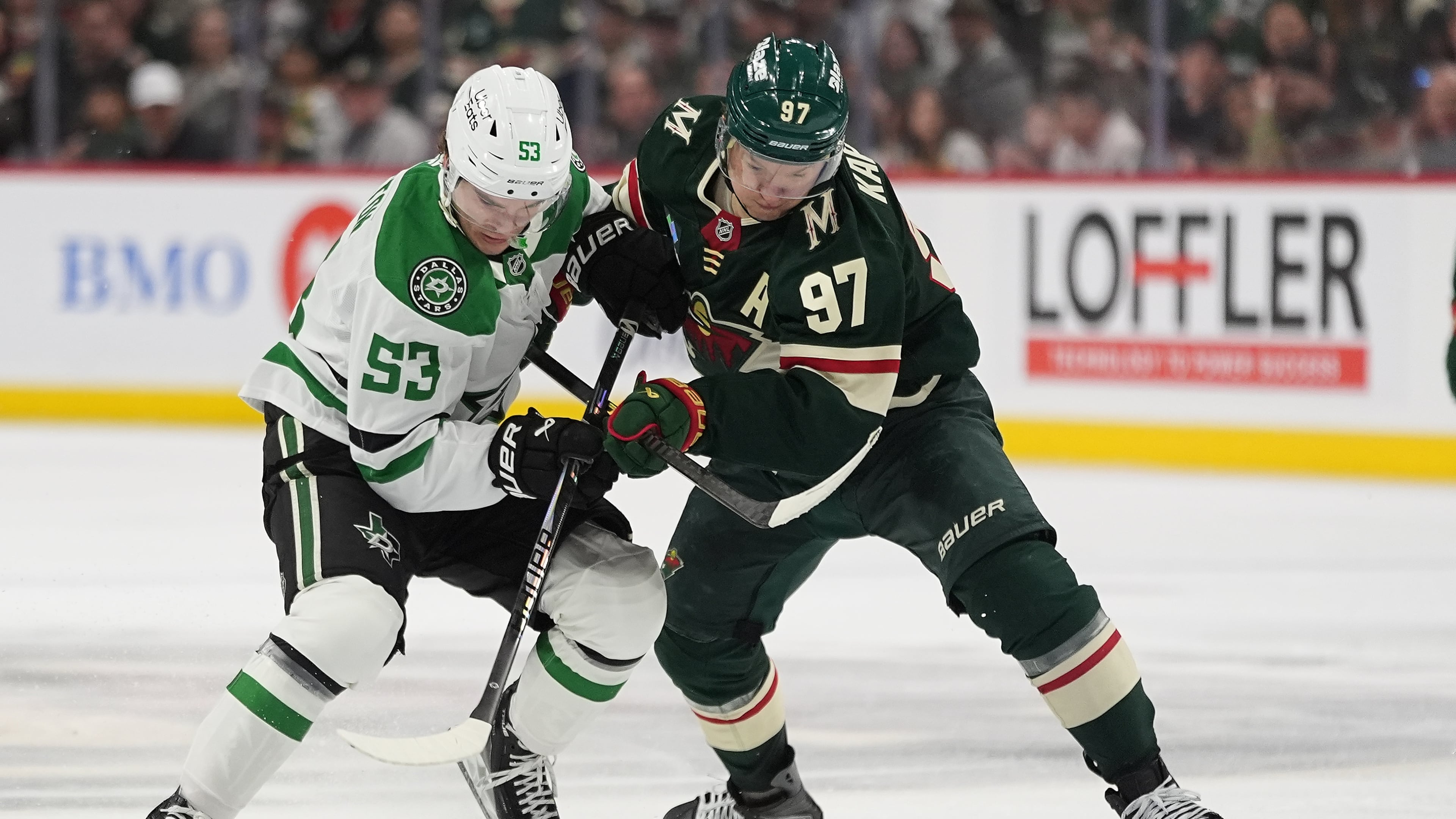 Dallas Stars center Wyatt Johnston (53) and Minnesota Wild left wing Kirill Kaprizov (97) battle for the puck during the second period of Game 3 in the first round of the NHL Stanley Cup hockey playoffs Wednesday, April 22, 2026, in St. Paul, Minn. (AP Photo/Abbie Parr)