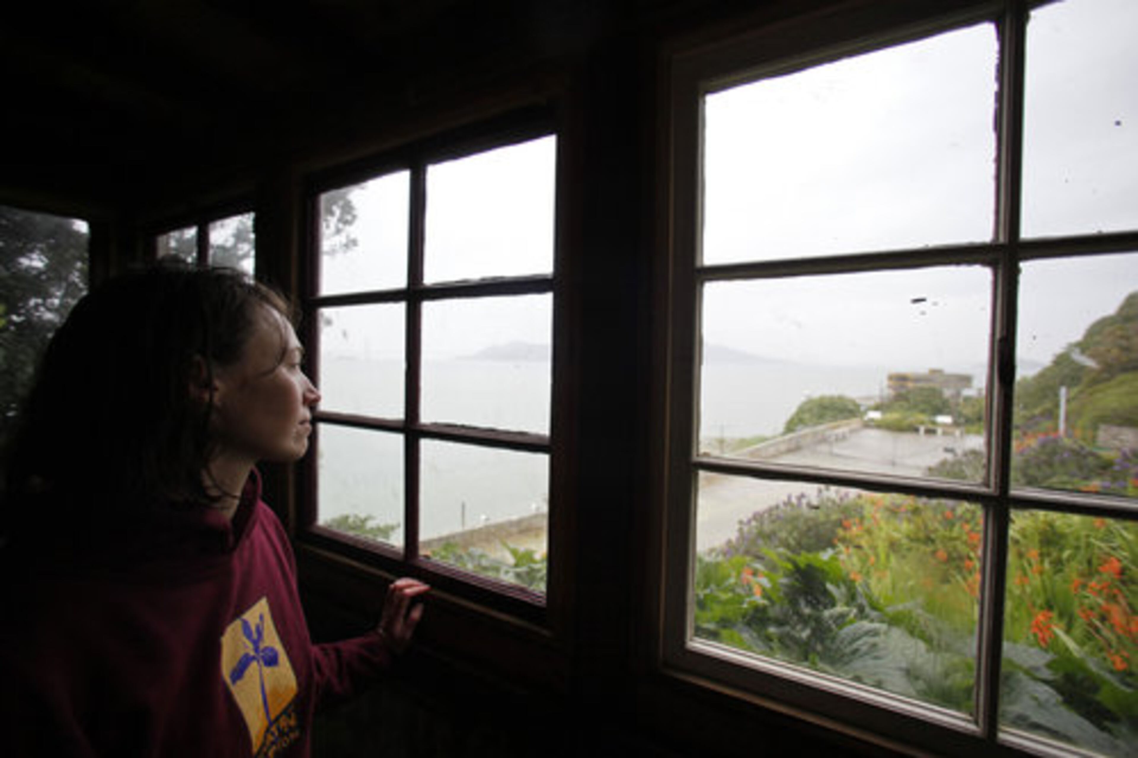 Shelagh Fritz, project manager of the Alcatraz Historic Gardens Project, looks out from a tool shed originally built by prisoners onto gardens below the exercise yard on Alcatraz Island in San Francisco.