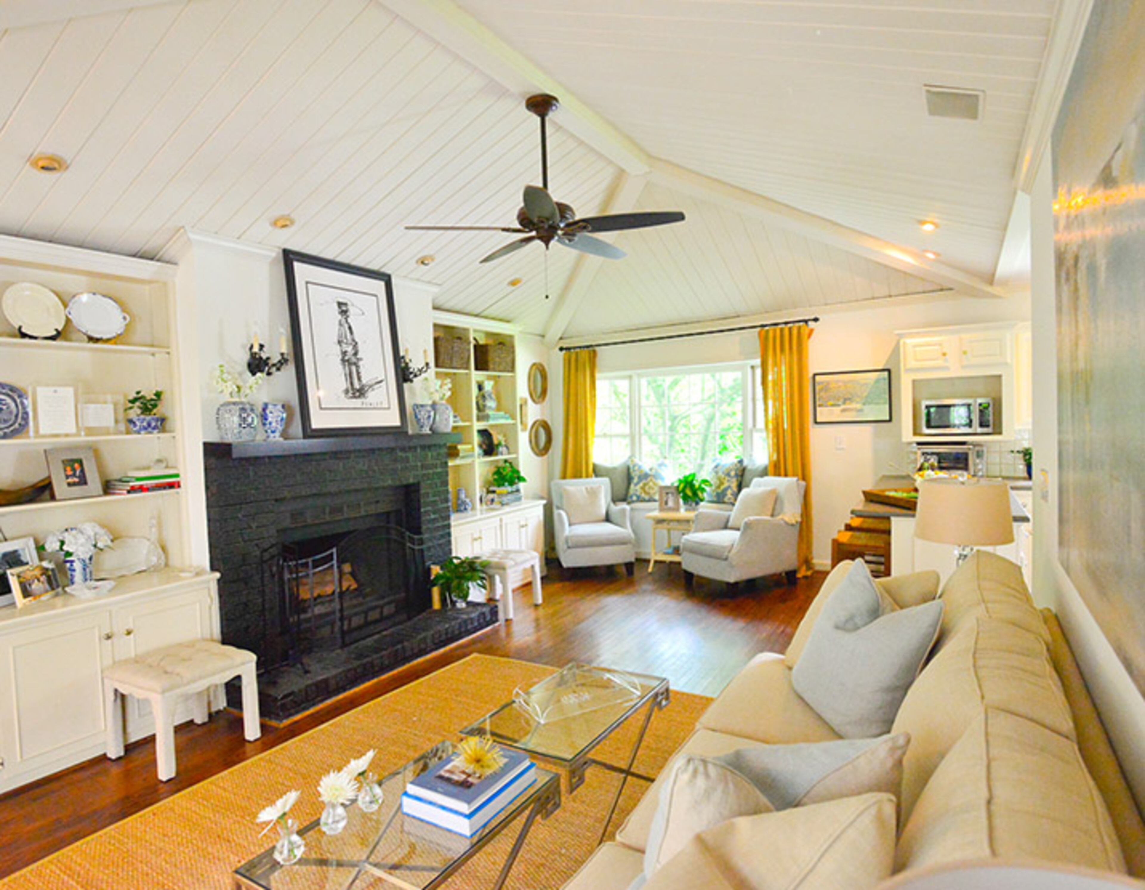 The mantle and brick were painted black to keep the look simple and consistent with the image a Coke bottle by Steve Penley, said homeowner TJ Callaway. The couch and glasstop tables are by Bernhardt.