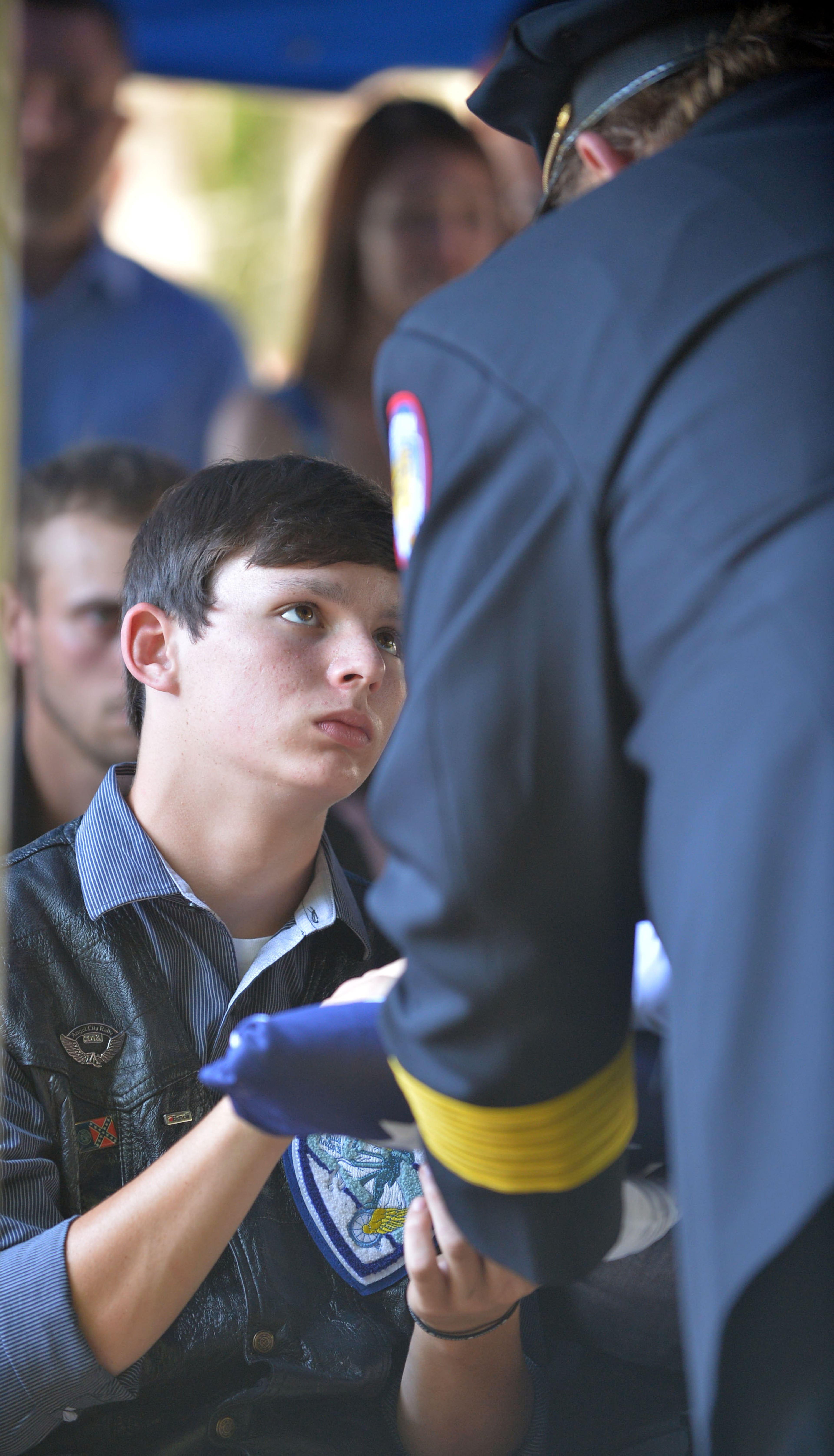 Zachary Hawk, son of police officer Noel Lee Hawk, is presented the flag by Eatonton Police Chief Kent Lawrence. Officer Noel Lee Hawk is survived by his children: Brittany Lowrey, Taylor Talley, Heather Brandt, Victoria Hawk and son Zachary. He also leaves a brother, Neal, and parents, Bobby and Martha Hawk.