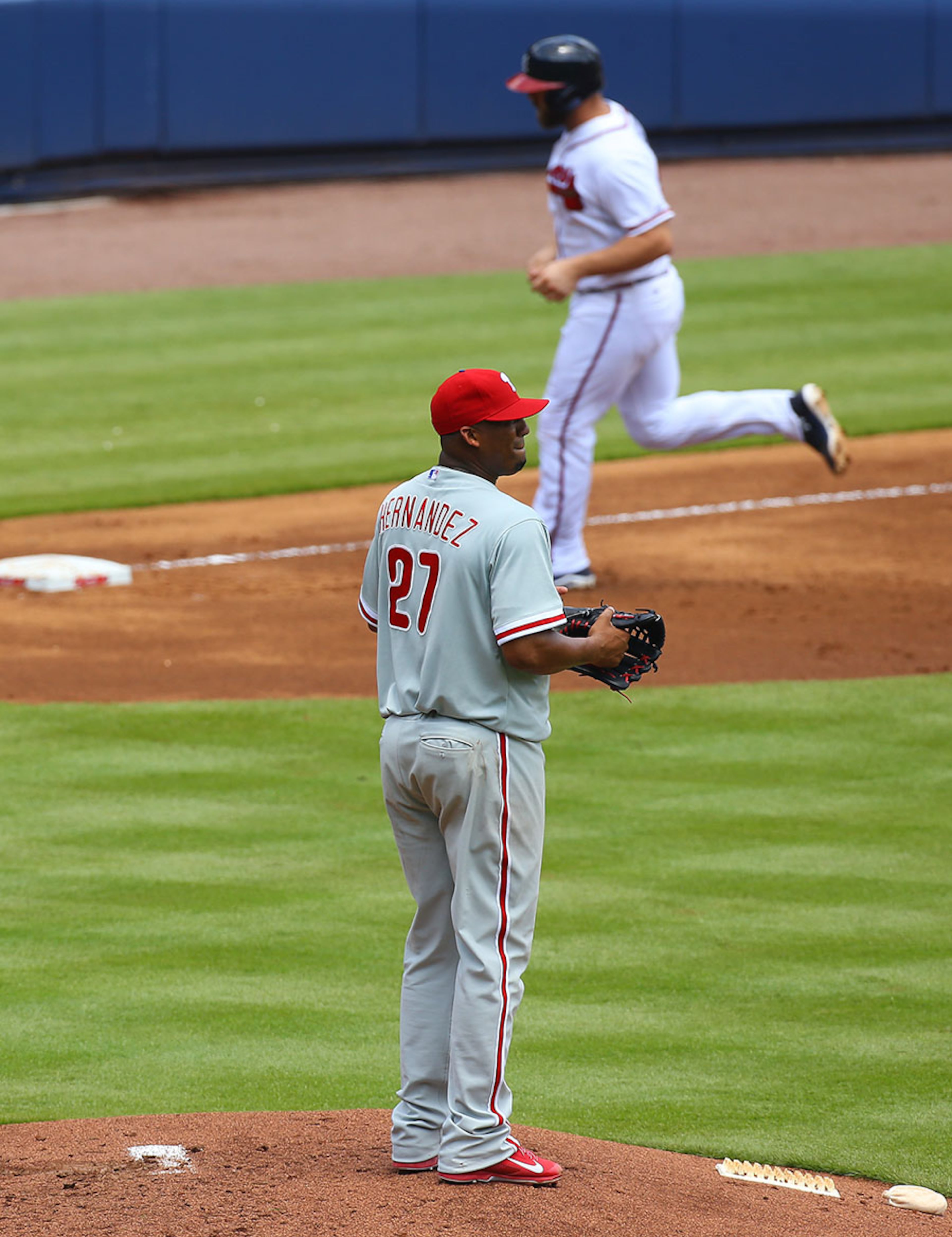 Phillies pitcher Roberto Hernandez glances toward the outfield while Braves Evan Gattis circles the bases on his 2-run homer.