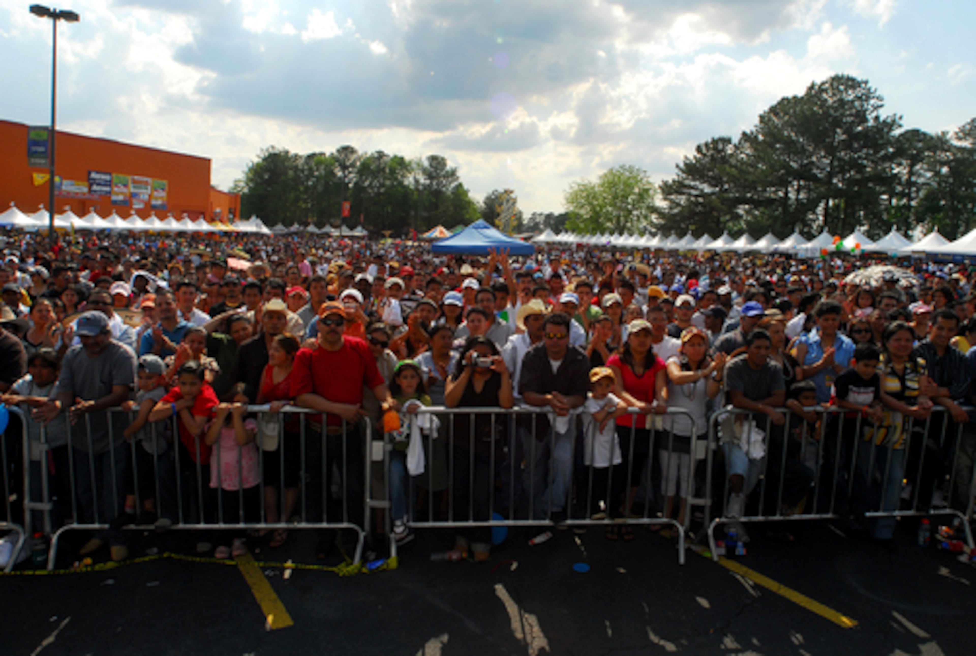 Gates block the thousands of people who gathered Sunday in the parking area behind the Fiesta Plaza mall for a Cinco de Mayo celebration.